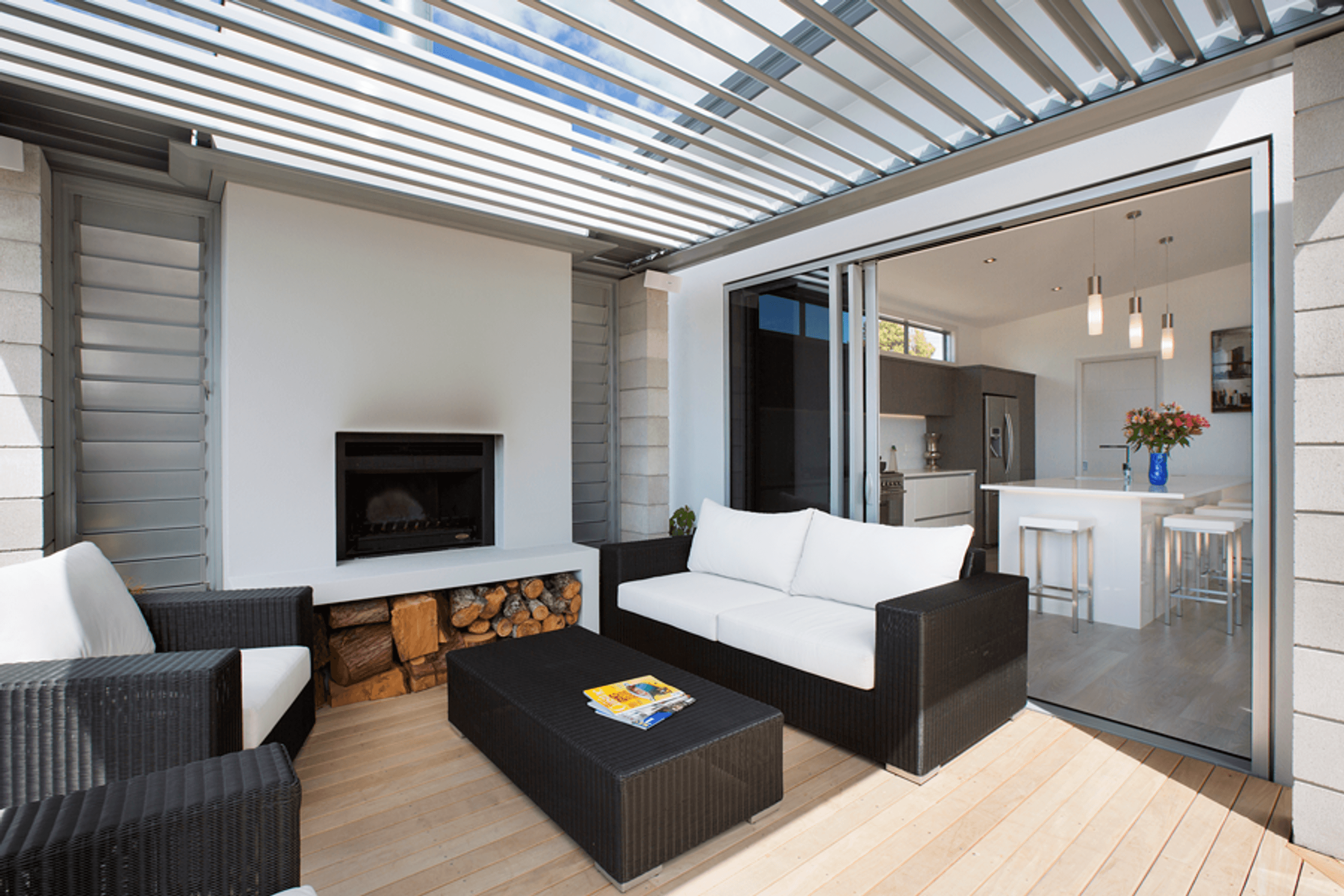 The home features an outdoor alfresco living area with louvretec roof and open wood fire that captures the views and leads off the living spaces