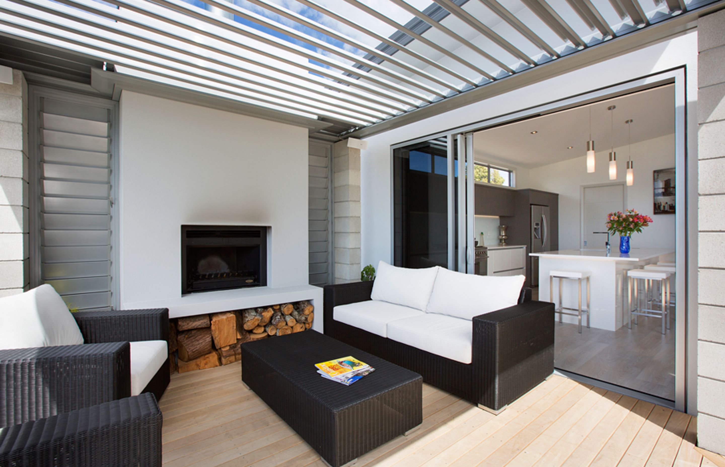 The home features an outdoor alfresco living area with louvretec roof and open wood fire that captures the views and leads off the living spaces