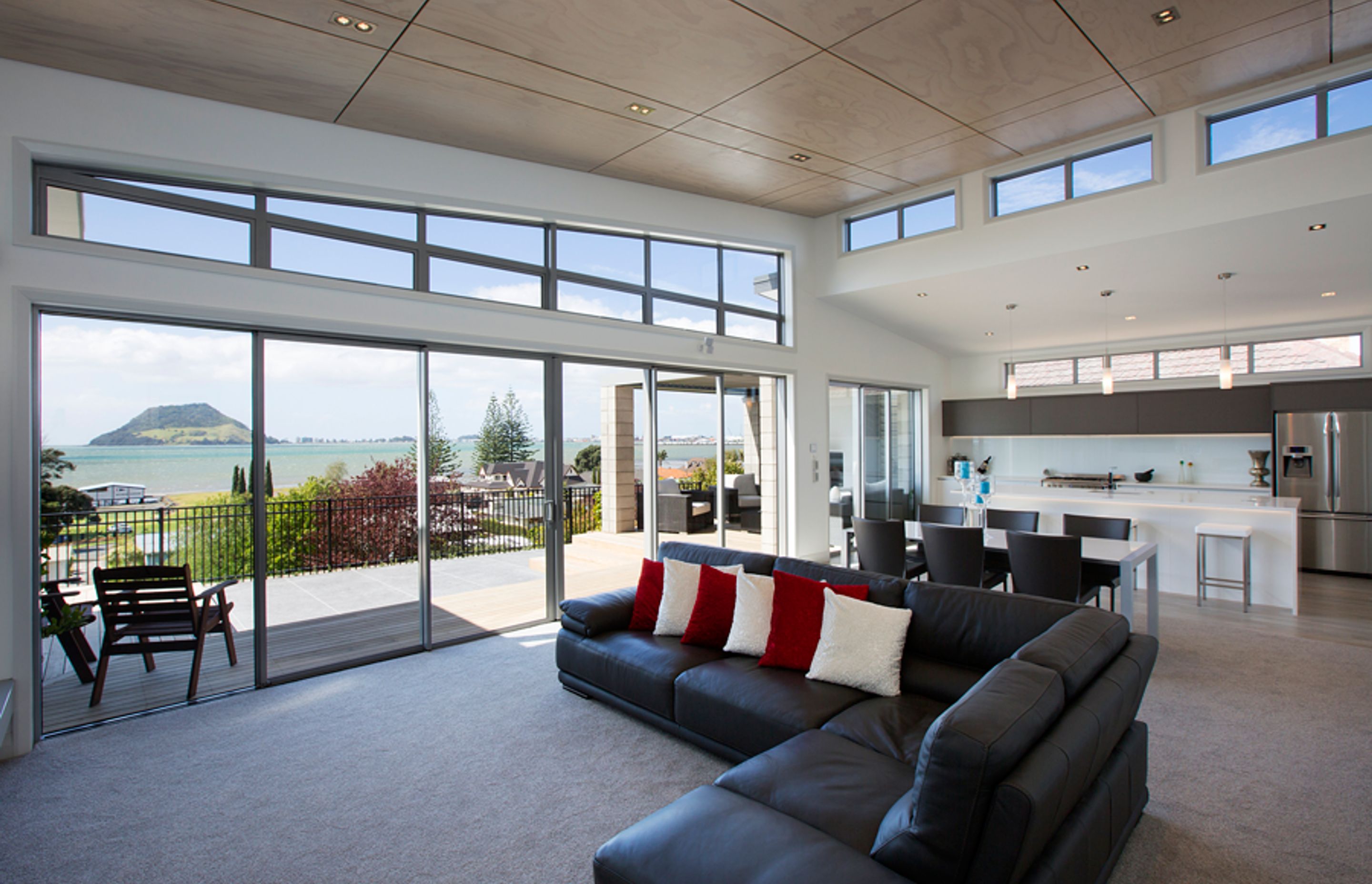 Open plan living spans across from kitchen to dining to lounge and feature blonded ply ceilings with negative detailing.  