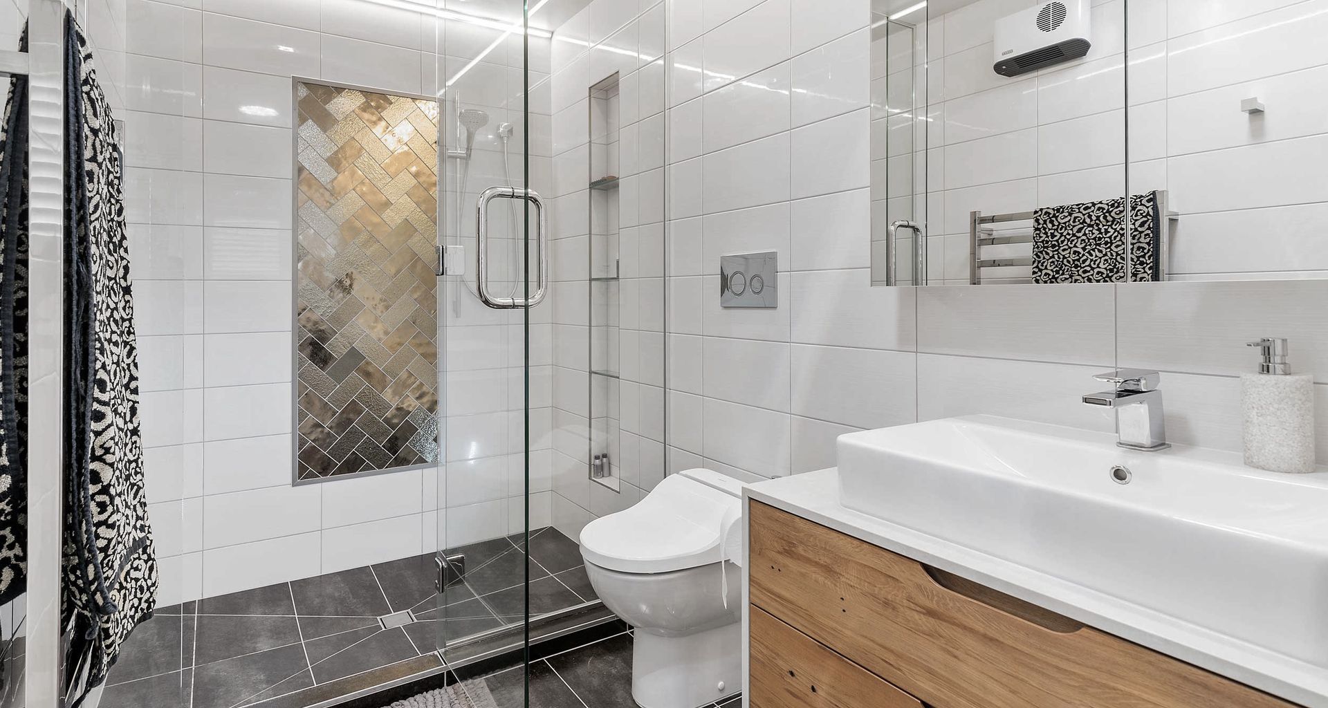 Ensuite bathroom with double shower, custom vanity, mirror storage and bidet
