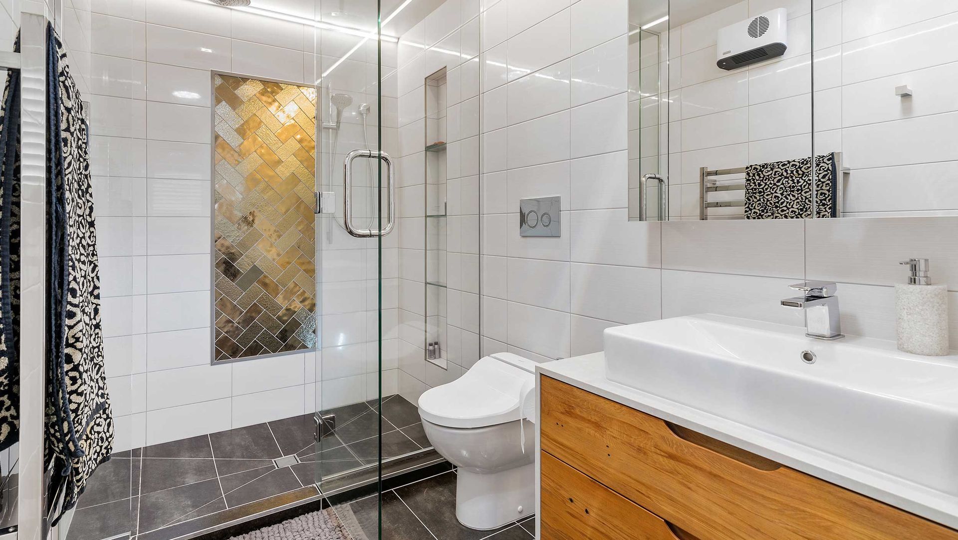 Ensuite bathroom with double shower, custom vanity, mirror storage and bidet