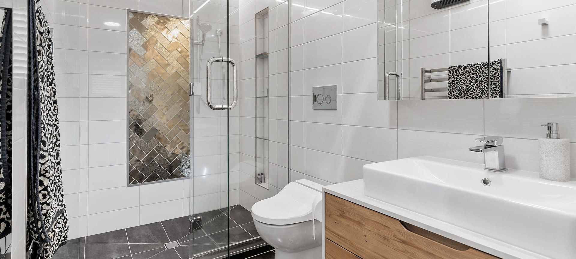 Ensuite bathroom with double shower, custom vanity, mirror storage and bidet