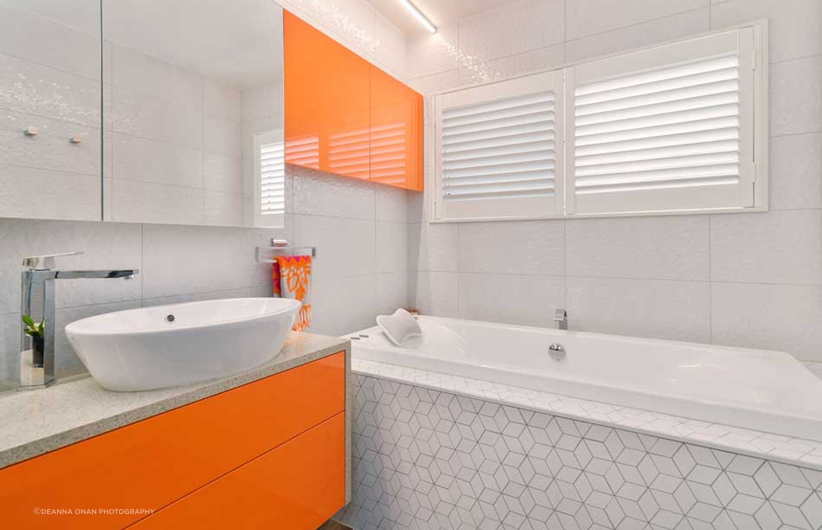 The hexagon design is in both the wall tiles and further enhanced with the mosaic tiles around the bath