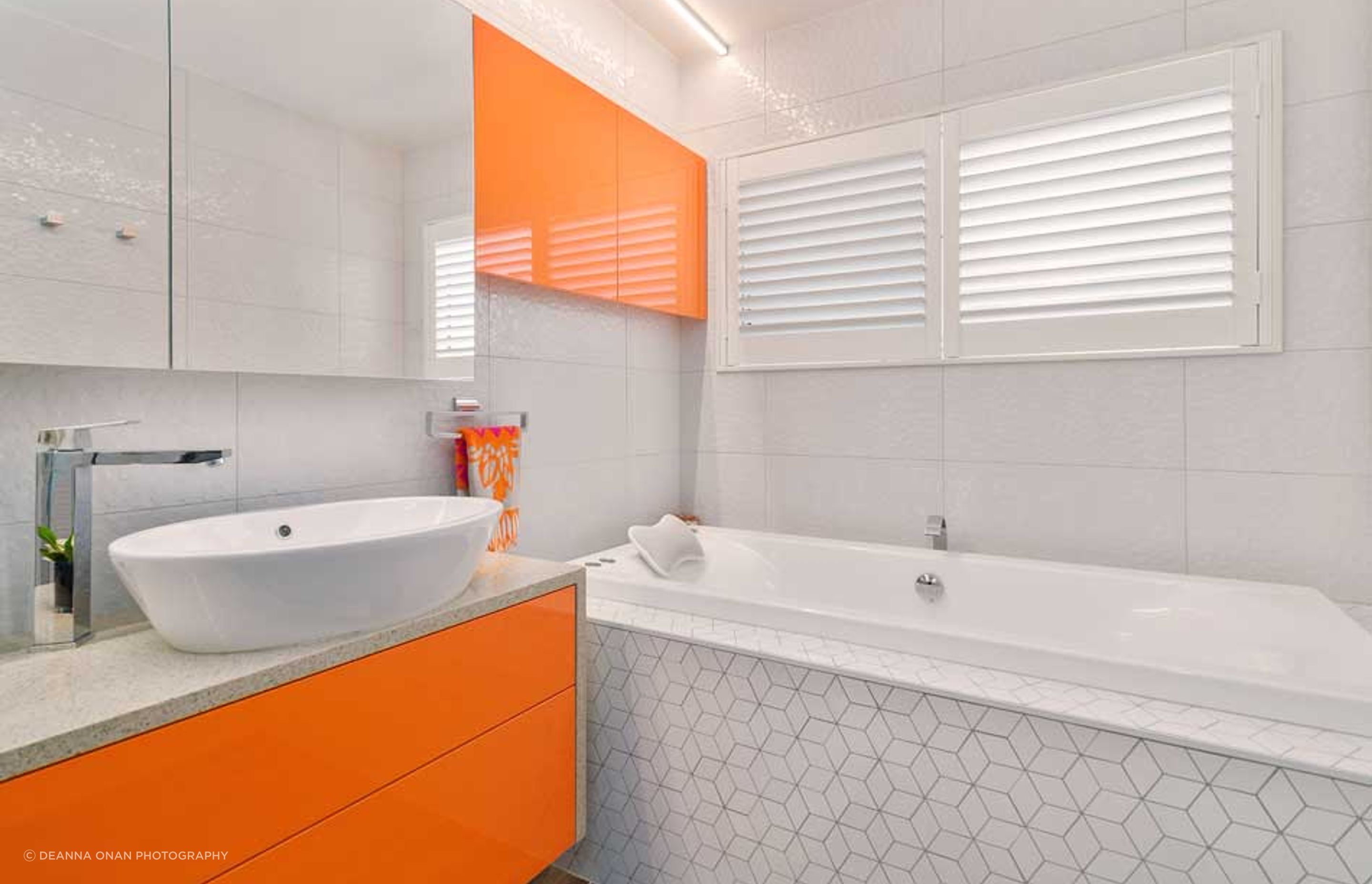 The hexagon design is in both the wall tiles and further enhanced with the mosaic tiles around the bath