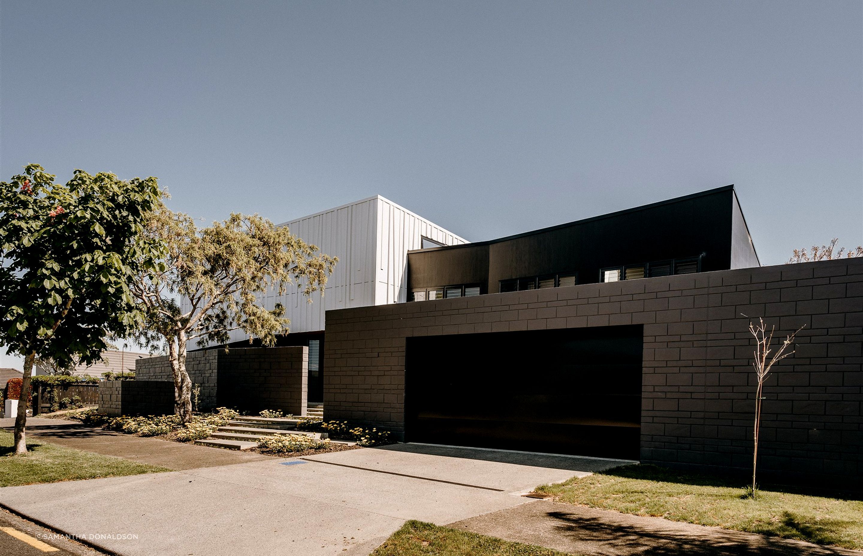 Block walls that front the garage extend out to the west to create a semi-private entrance area.