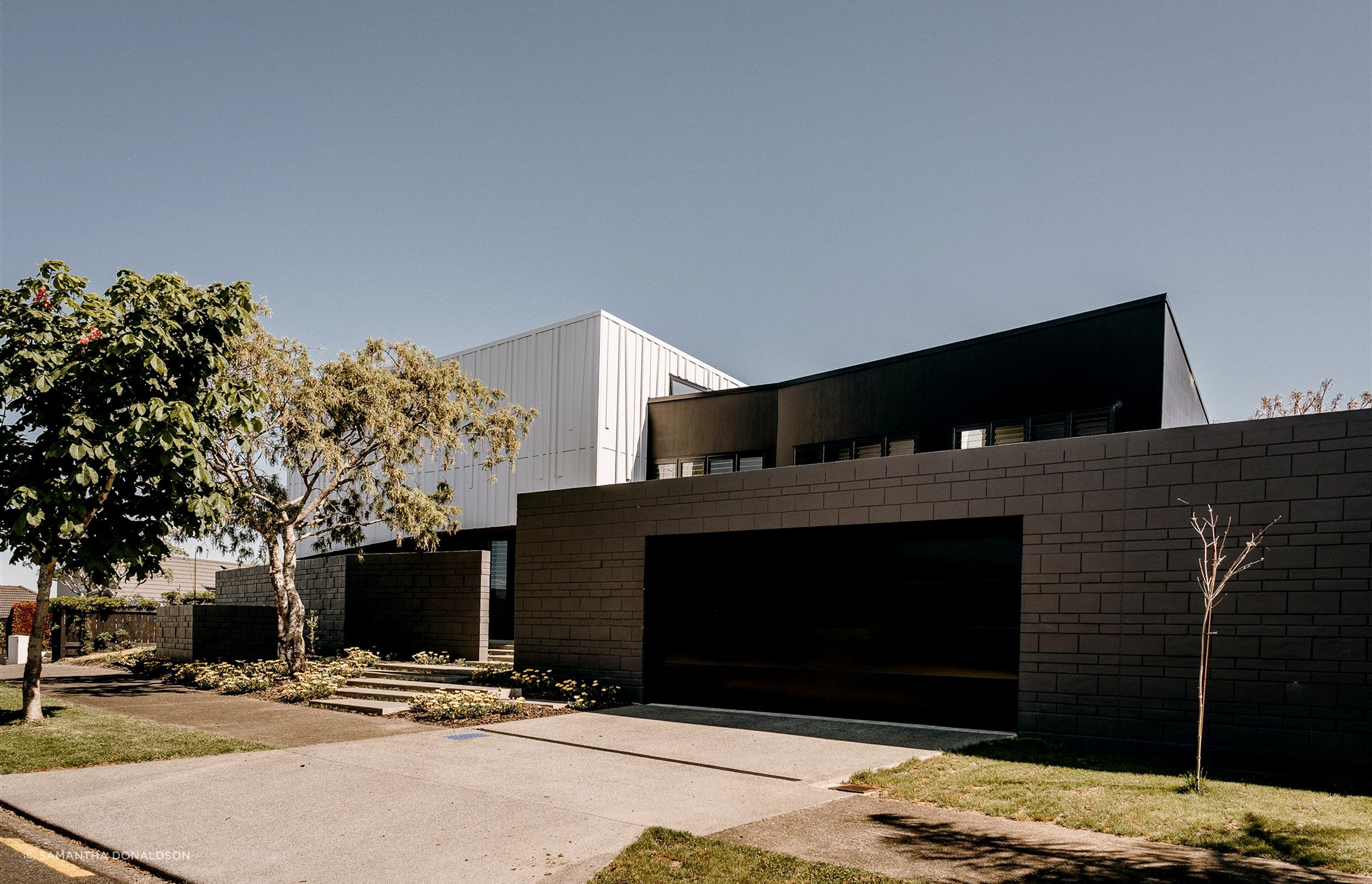 Block walls that front the garage extend out to the west to create a semi-private entrance area.