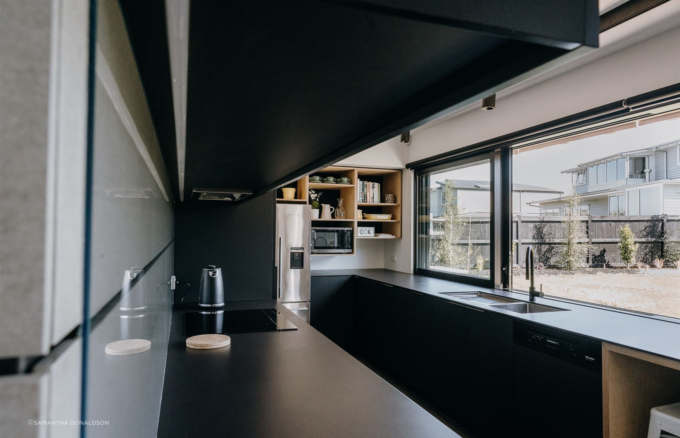 Matte black and timber are the central features in the kitchen, creating a consistent aesthetic in line with the other areas of the home. 