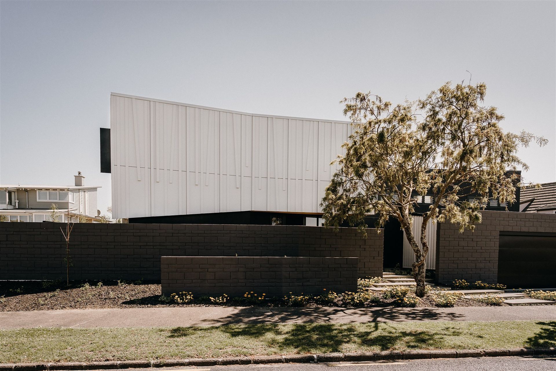 The form of the house follows the slight curve of the site while the ridgeline is angled to accentuate the slight undulations of the land.