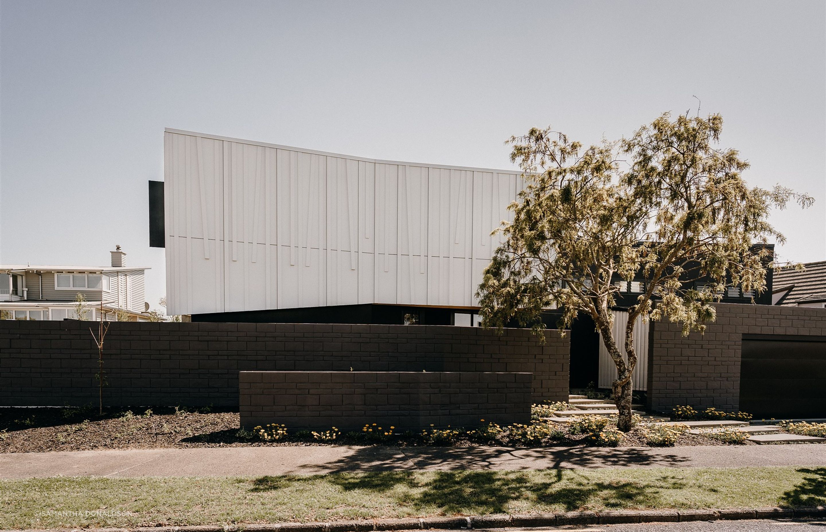 The form of the house follows the slight curve of the site while the ridgeline is angled to accentuate the slight undulations of the land.