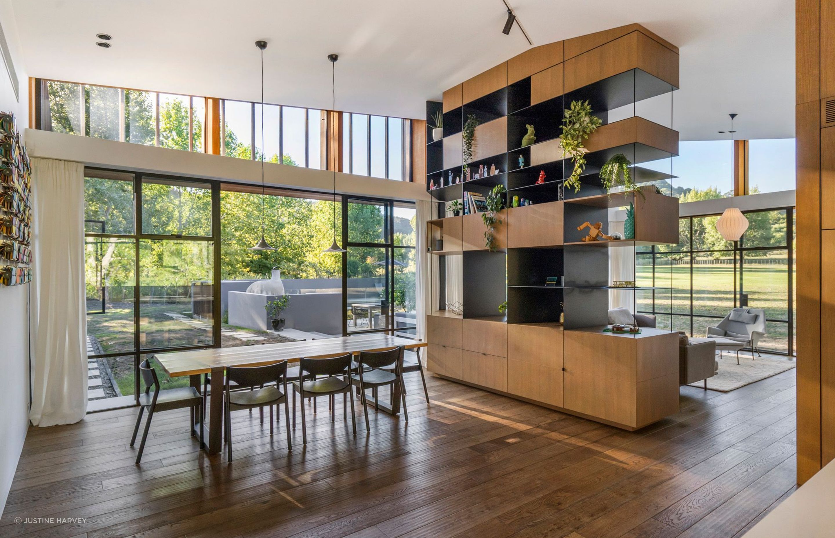 A huge floor-to-ceiling room divider in timber and steel is a key feature of the open-plan dining and lounge area.