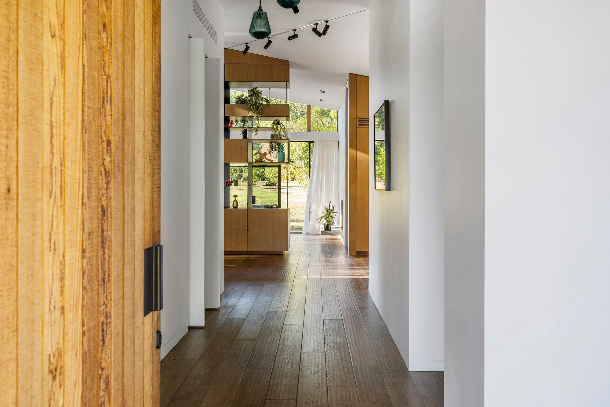 From the cedar front door, the view culminates in lush greenery at the other end of the house.