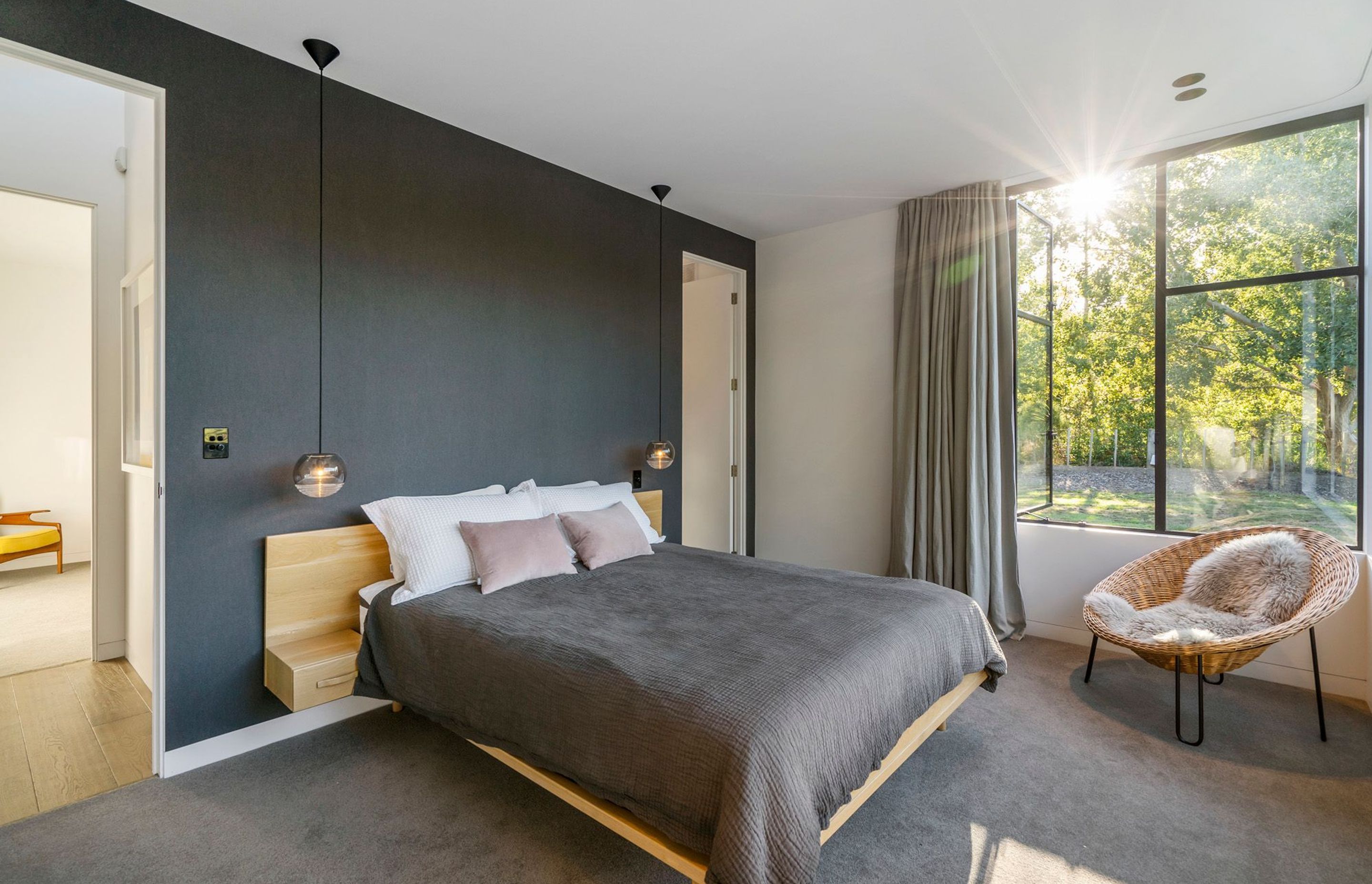 Grey on grey, the neutral palette of the master bedroom is an effective counterpoint to all the timber throughout the house and the surrounding green landscape.