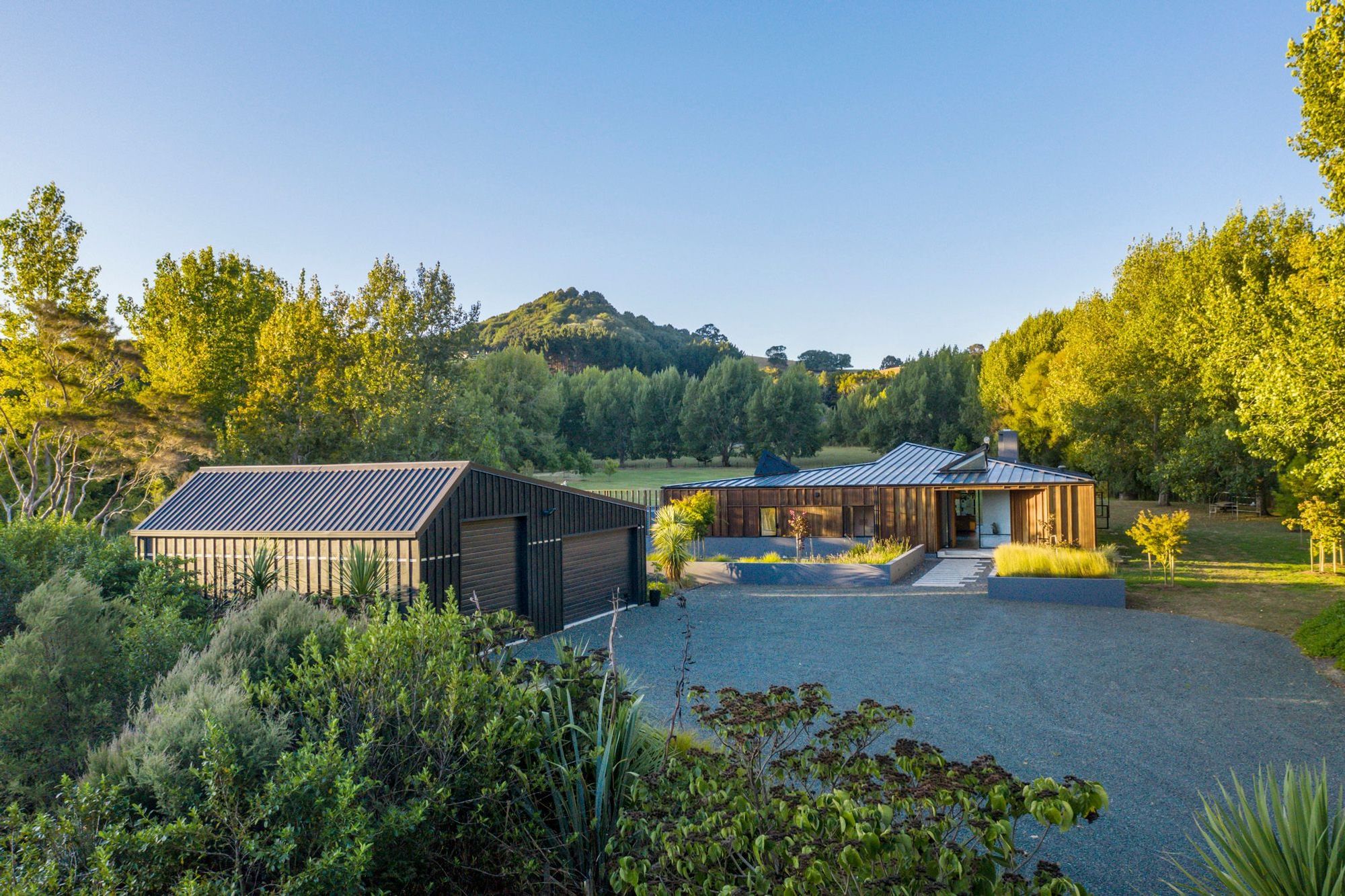 The distinctive roof angles start as soon as you arrive and park beside the garage with its asymmetrical roof, while the roof of Matakana House points towards Sugar Loaf Mountain.