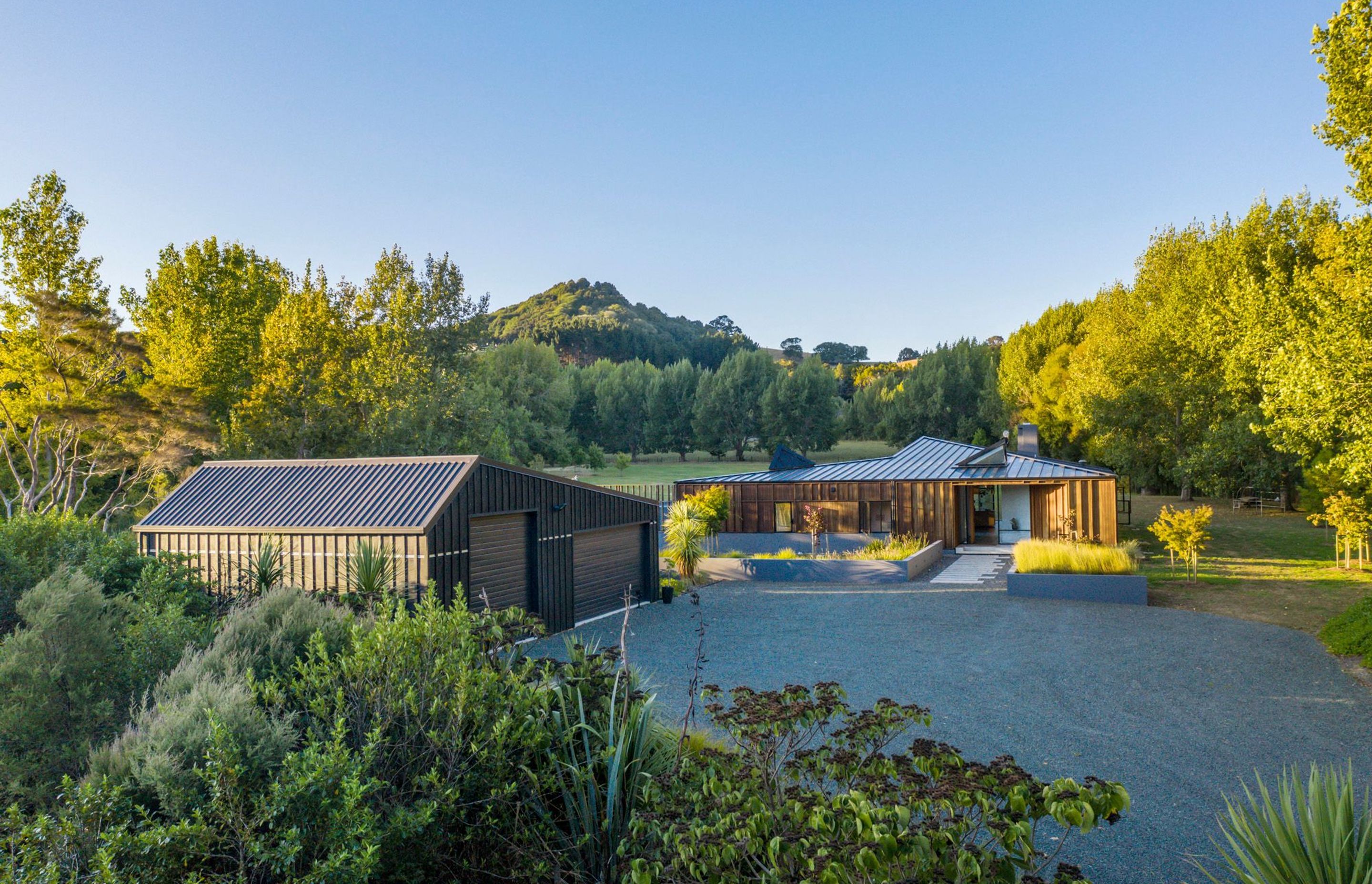 The distinctive roof angles start as soon as you arrive and park beside the garage with its asymmetrical roof, while the roof of Matakana House points towards Sugar Loaf Mountain.