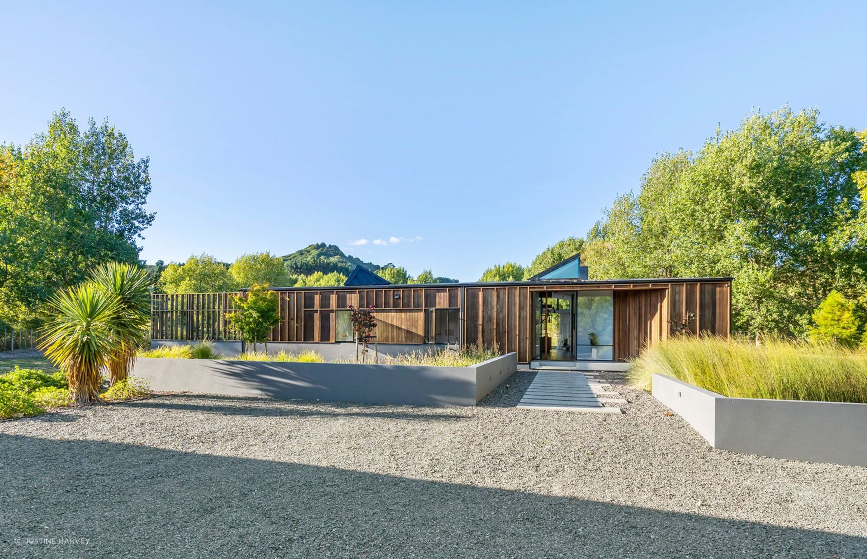 The board-and-batten, cedar-clad house sympathetically blends into its rural surroundings and a landscape planted in native plants and grasses, poplar trees and a fruit orchard.