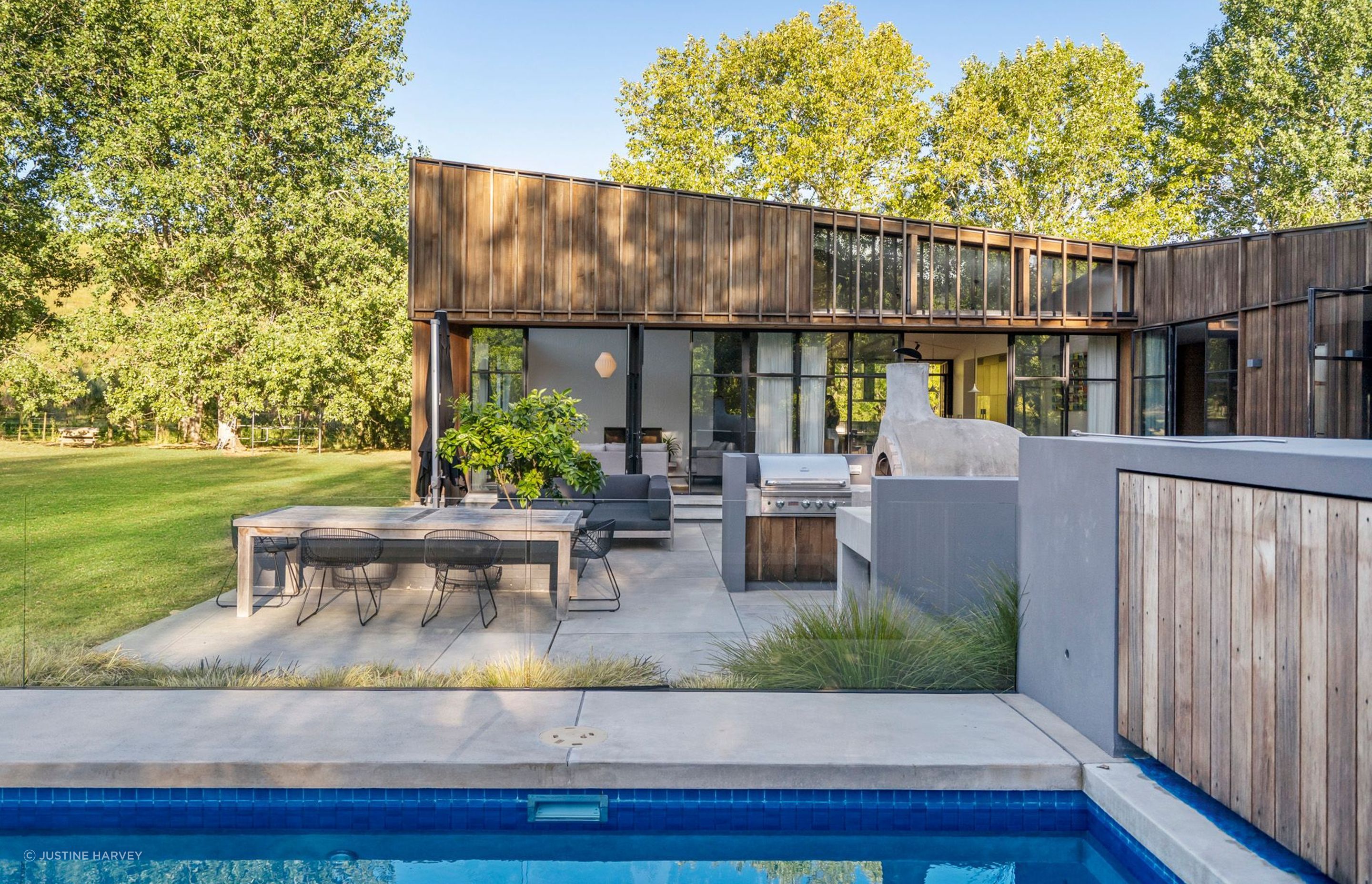 The northwestern-facing courtyard features an outdoor dining area complete with BBQ and Italian-style pizza oven.
