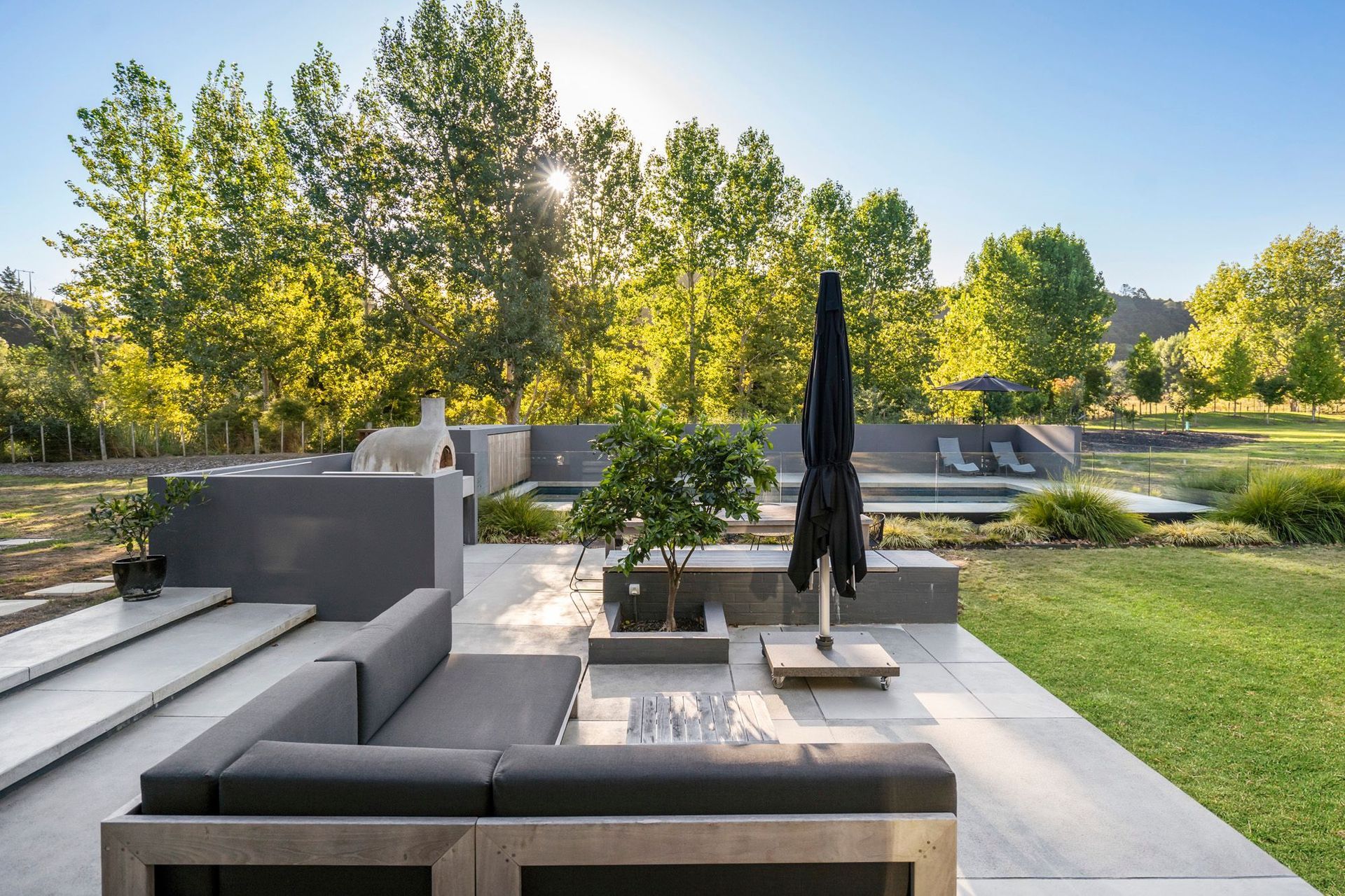 The outdoor lounge overlooks the surrounding landscape, including a young orchard in the background of the photo, which was planted by the owners.