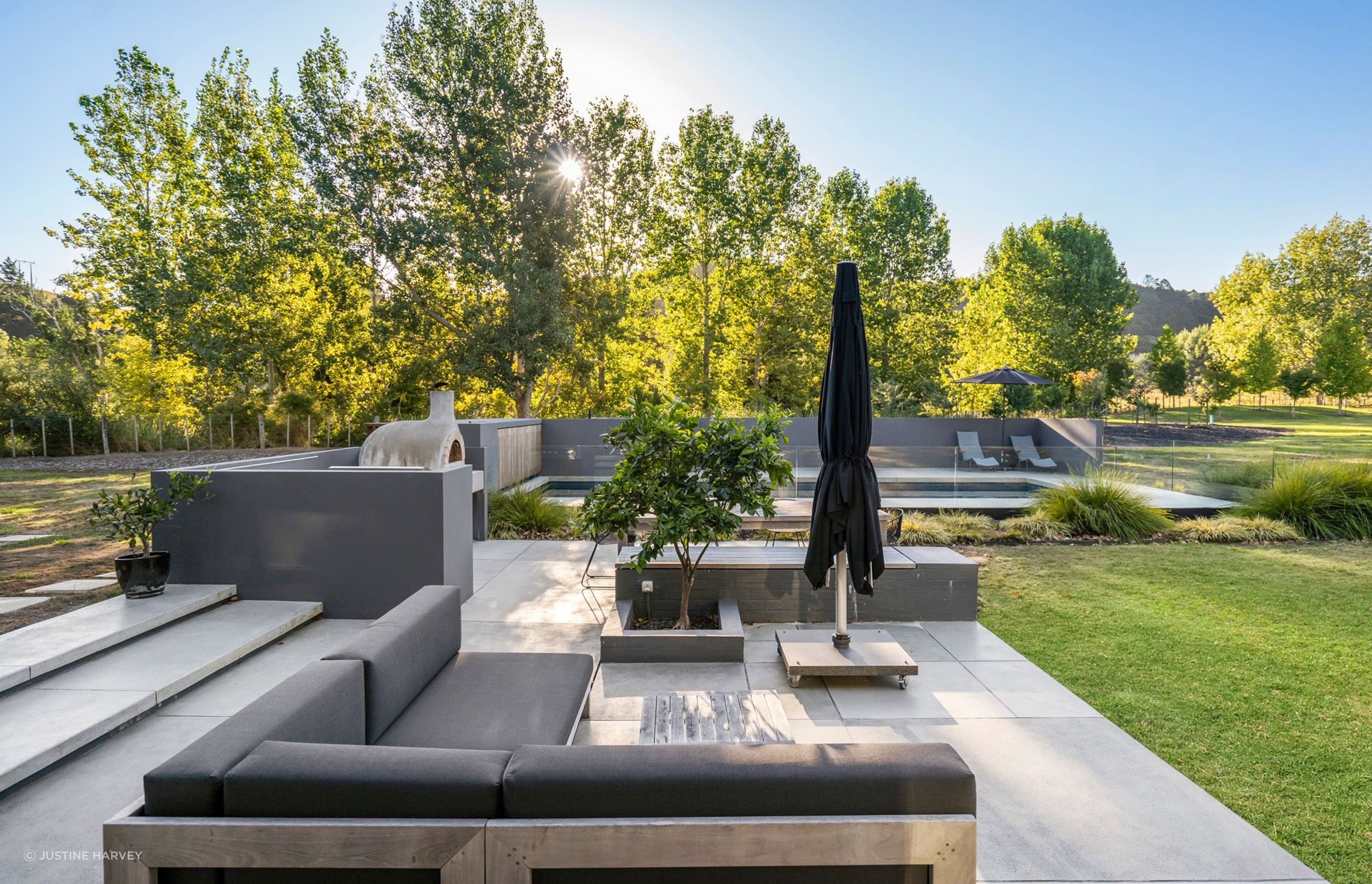 The outdoor lounge overlooks the surrounding landscape, including a young orchard in the background of the photo, which was planted by the owners.