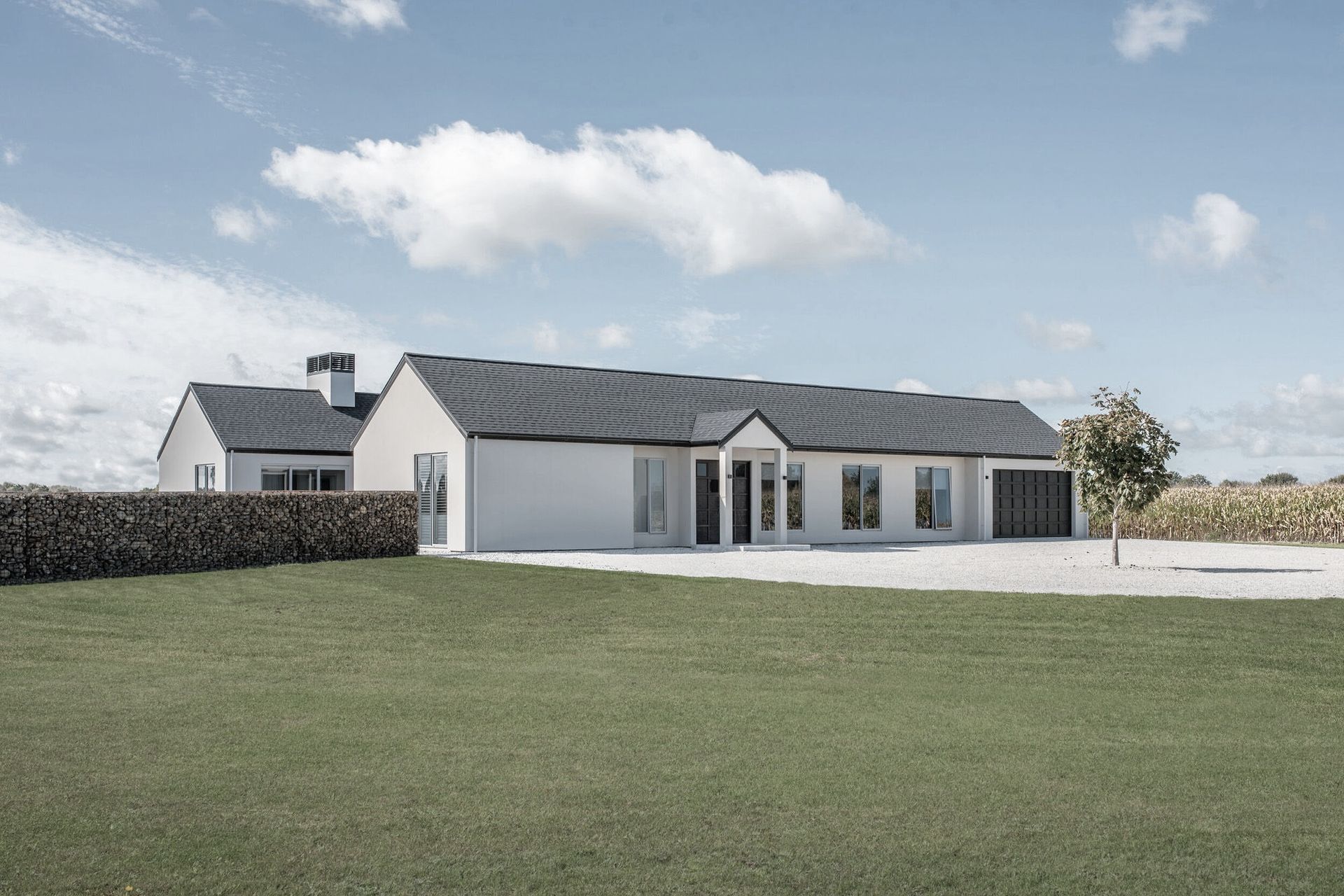 This modern farmhouse answers the clients' brief for a minimalist aesthetic with a refined material palette and European feel.