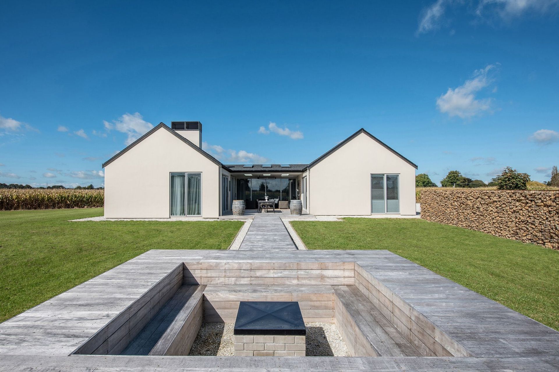 A conversation pit, somewhat removed from the house, provides a sense of being in the landscape yet connection to the built environment is maintained through the connecting walkway back to the house.