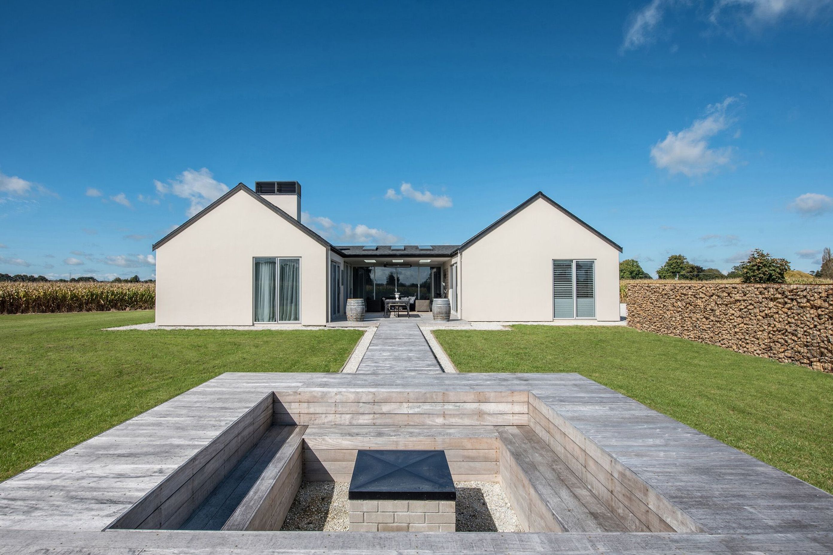 A conversation pit, somewhat removed from the house, provides a sense of being in the landscape yet connection to the built environment is maintained through the connecting walkway back to the house.