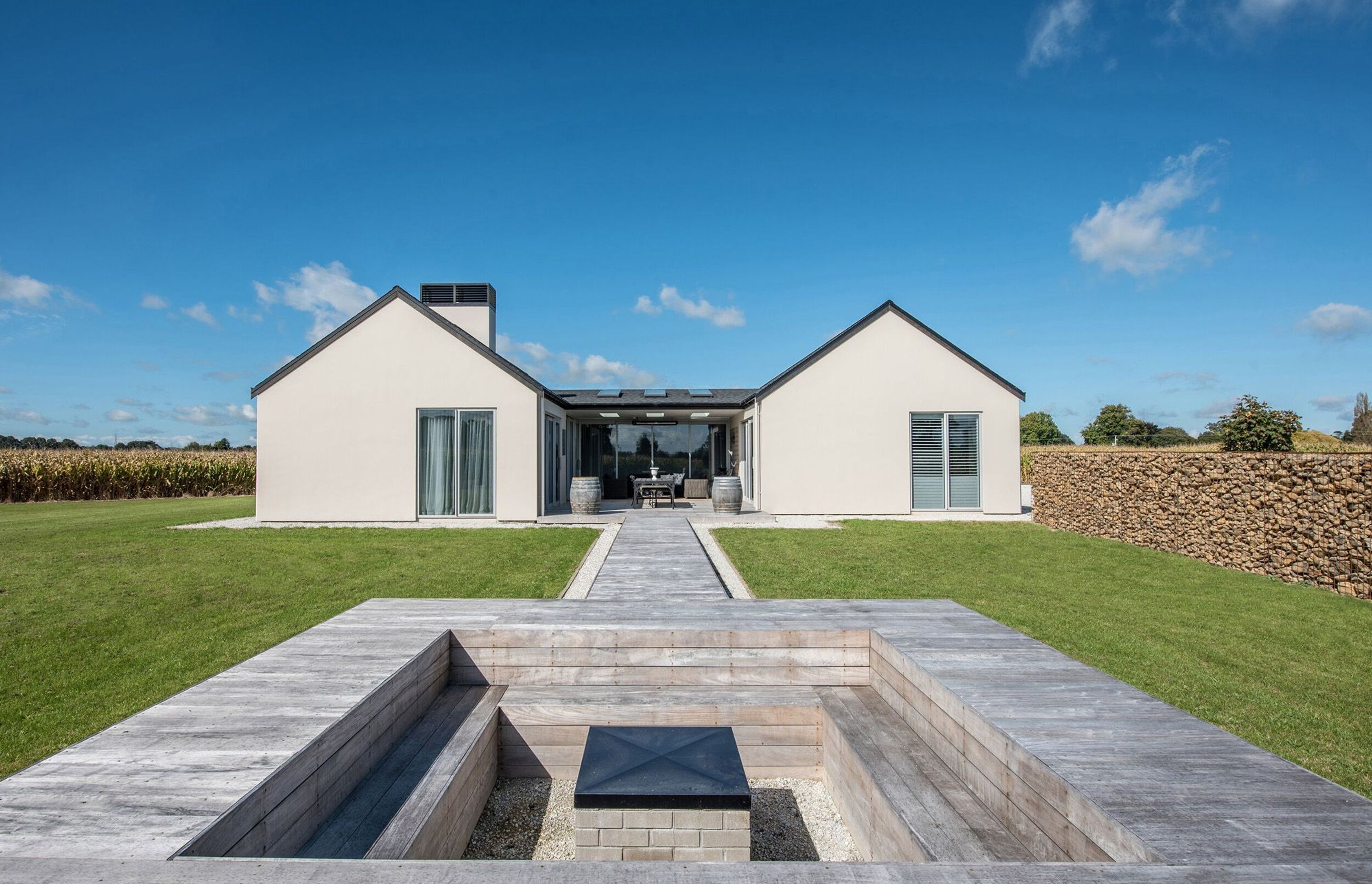 A conversation pit, somewhat removed from the house, provides a sense of being in the landscape yet connection to the built environment is maintained through the connecting walkway back to the house.