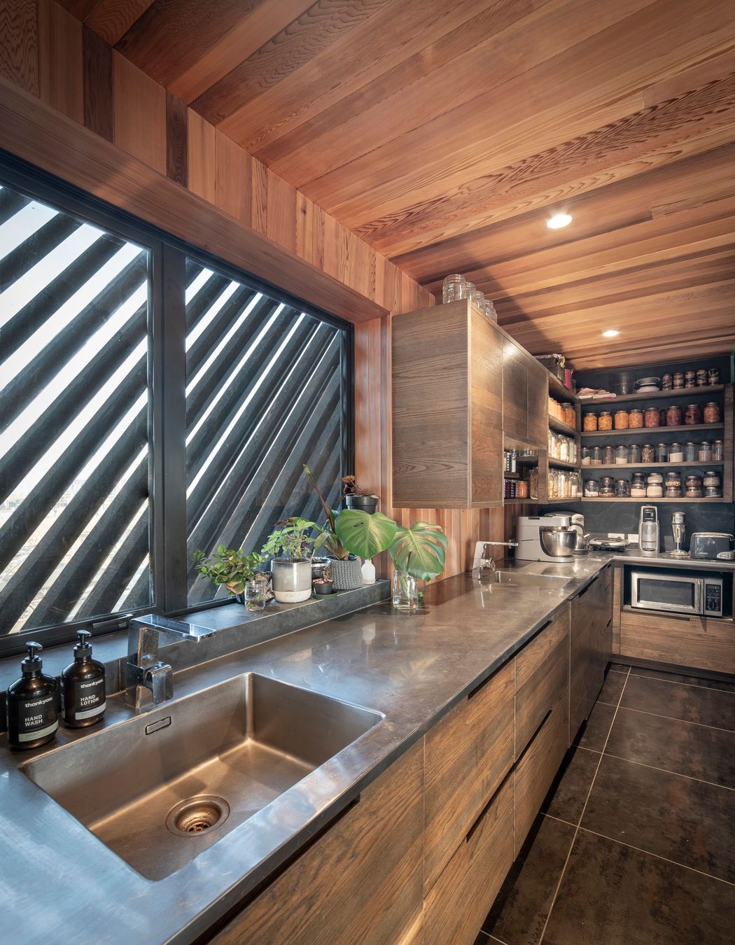 A long stainless-steel bench is a practical work surface in the kitchen and scullery.