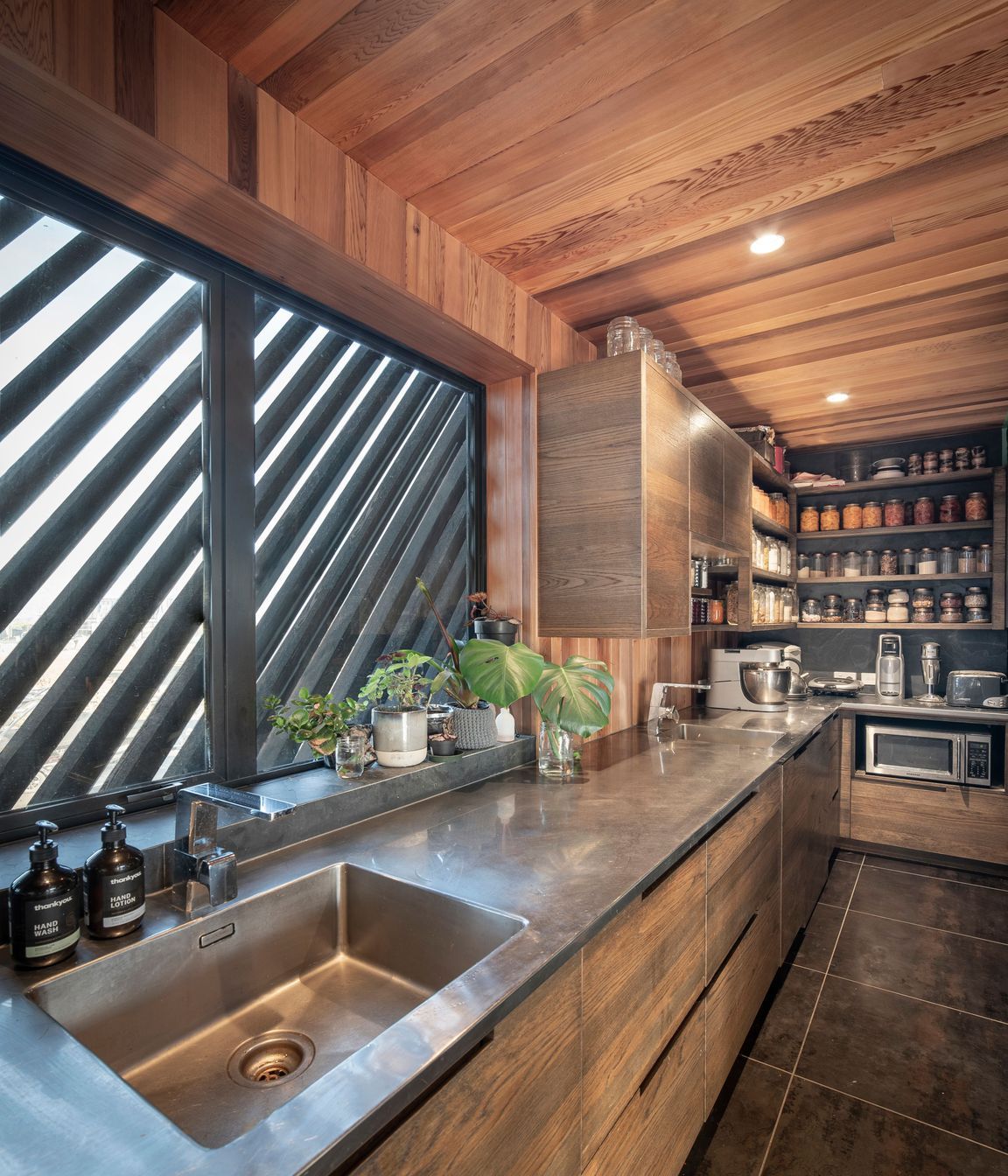 A long stainless-steel bench is a practical work surface in the kitchen and scullery.