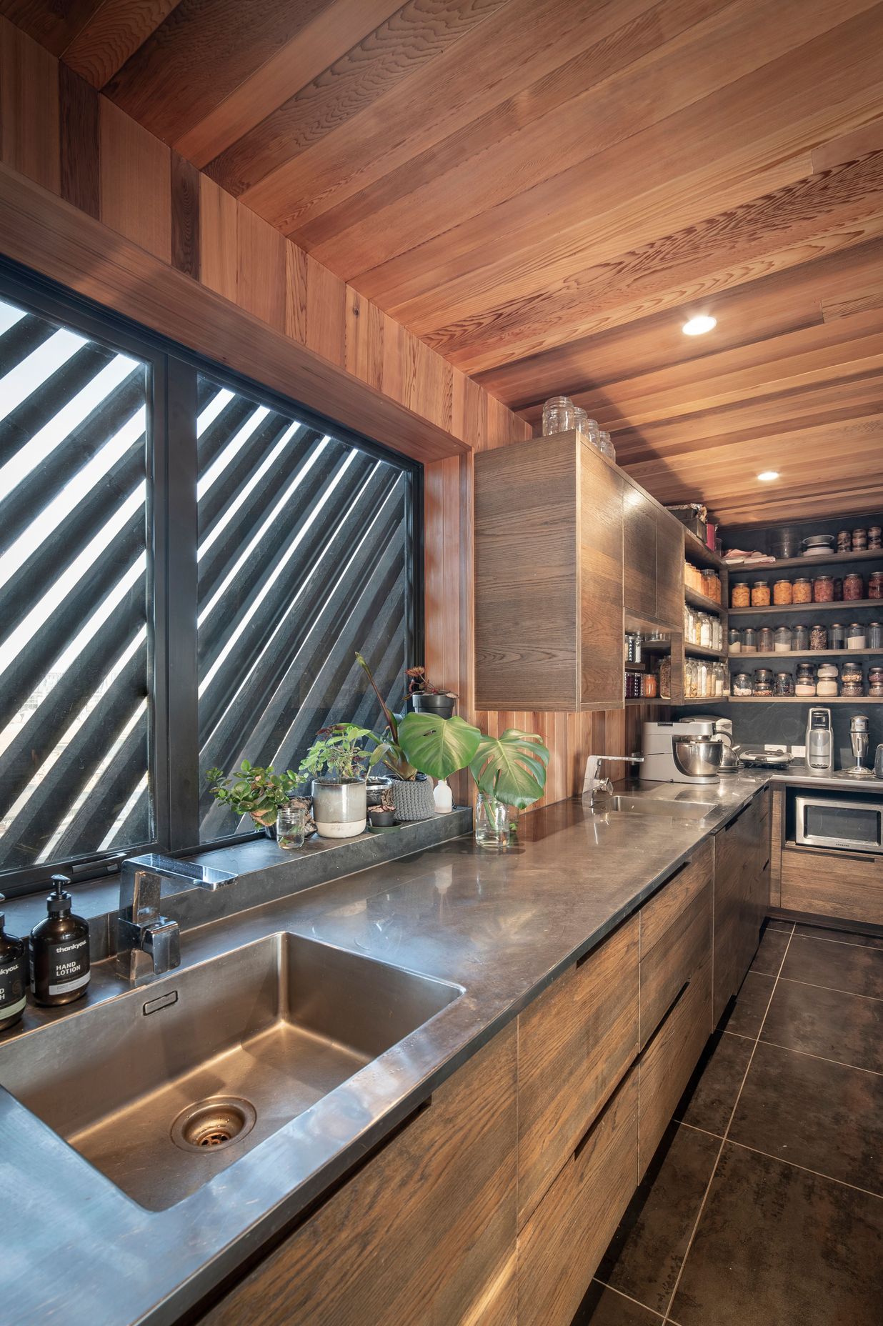 A long stainless-steel bench is a practical work surface in the kitchen and scullery.