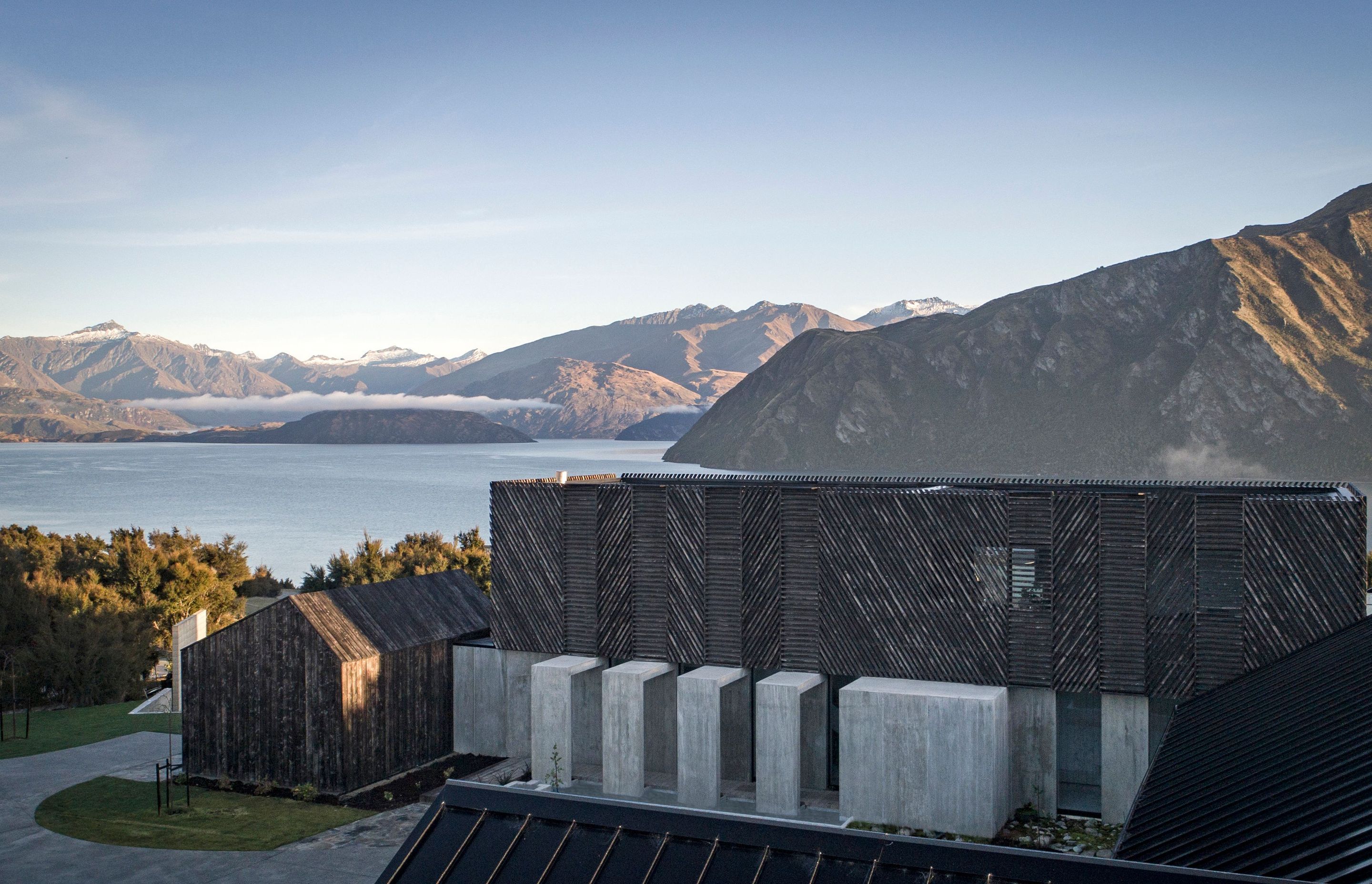 With stunning views of Lake Wanaka, this unusual home has distinctive charred timber cladding that blends beautifully into the surrounding hills and mountains.