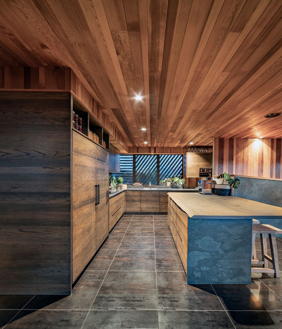 The kitchen is finished with a natural material palette of stone and timber.