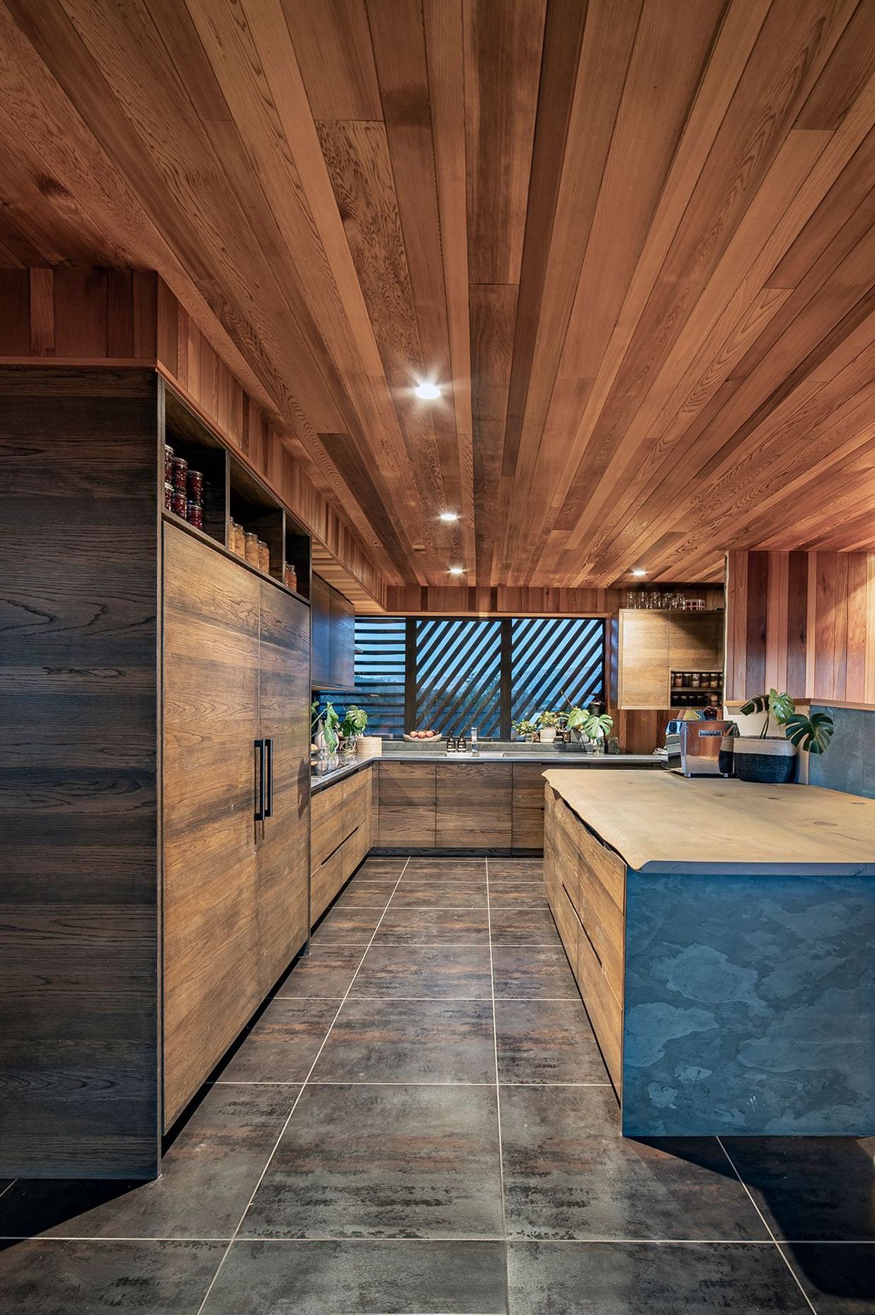 The kitchen is finished with a natural material palette of stone and timber.