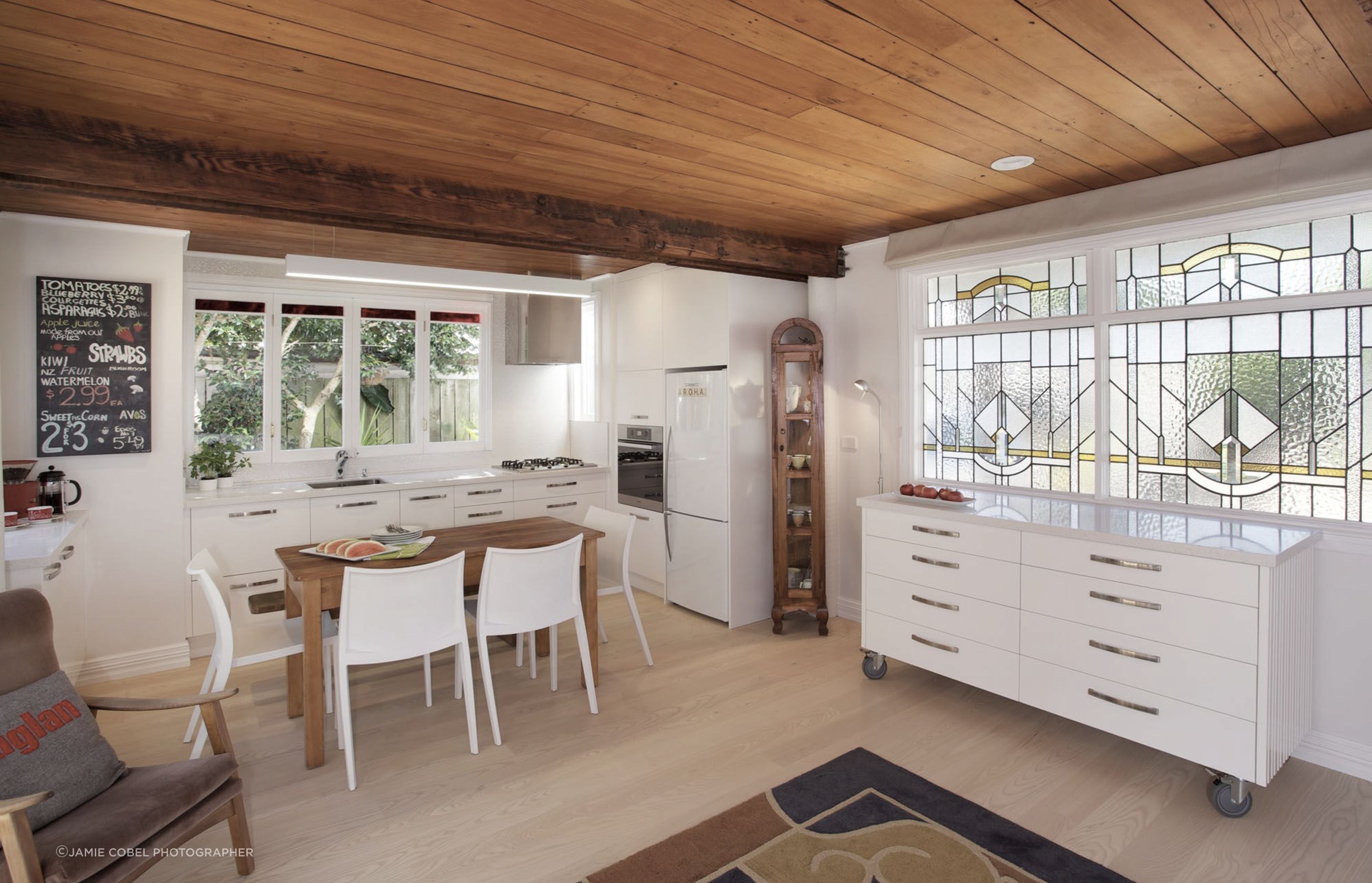 Here the island is shifted to below the leadlight window so the entire room can be utilised for dining or living. Perfect for the large gatherings of friends and families in such a compact efficient cottage.