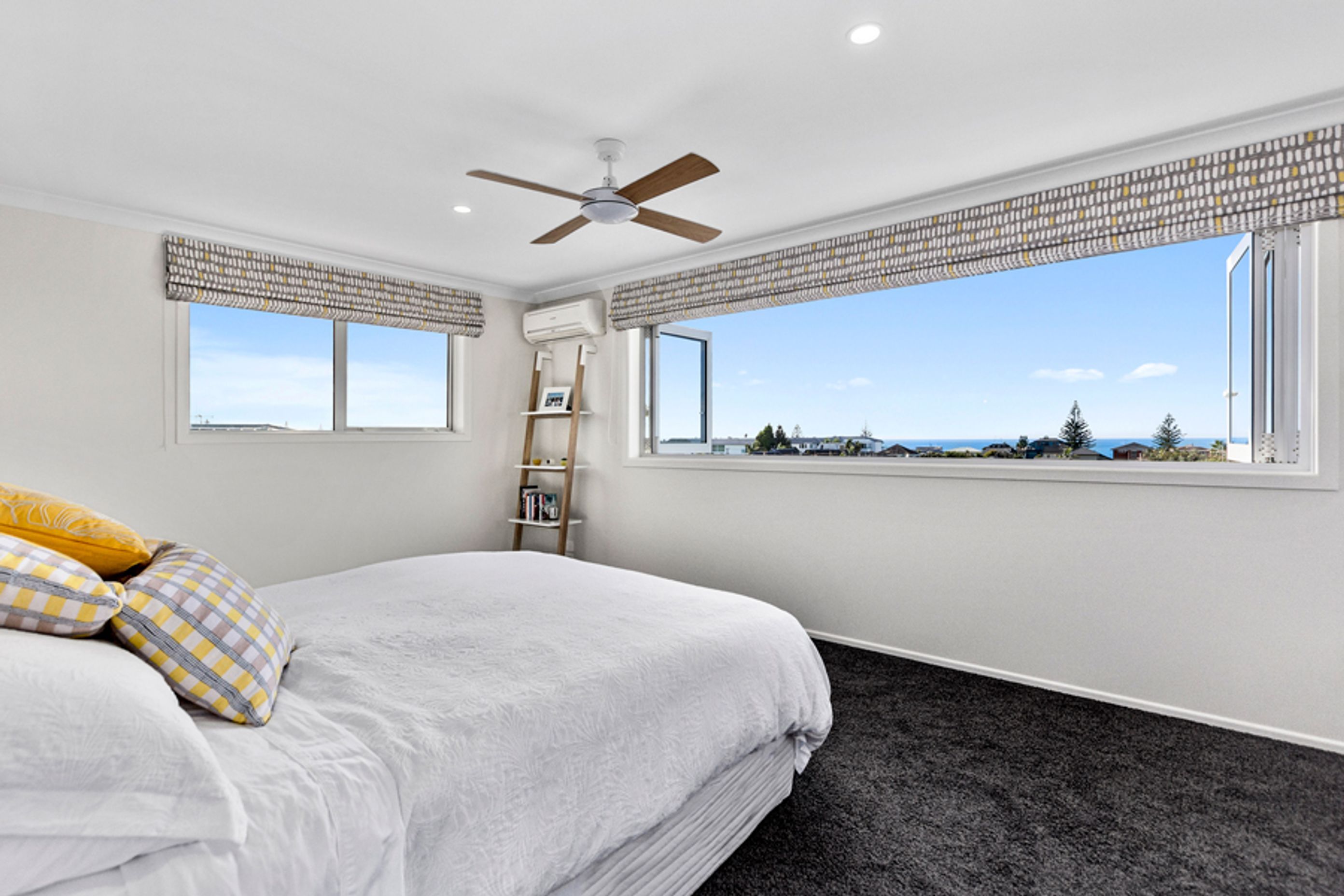 A bedroom with a stunning view of Mount Maunganui beach.