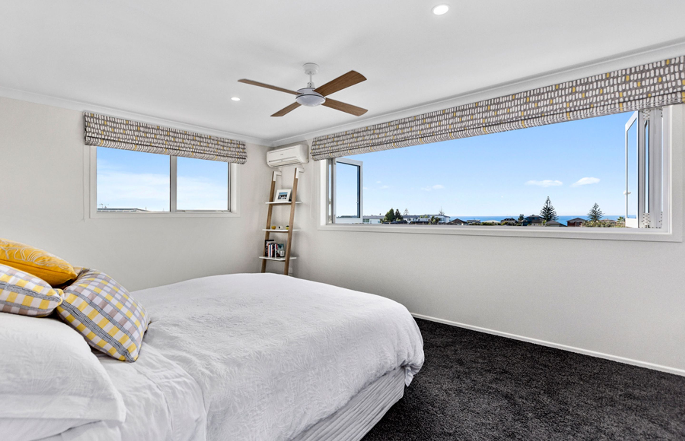 A bedroom with a stunning view of Mount Maunganui beach. 