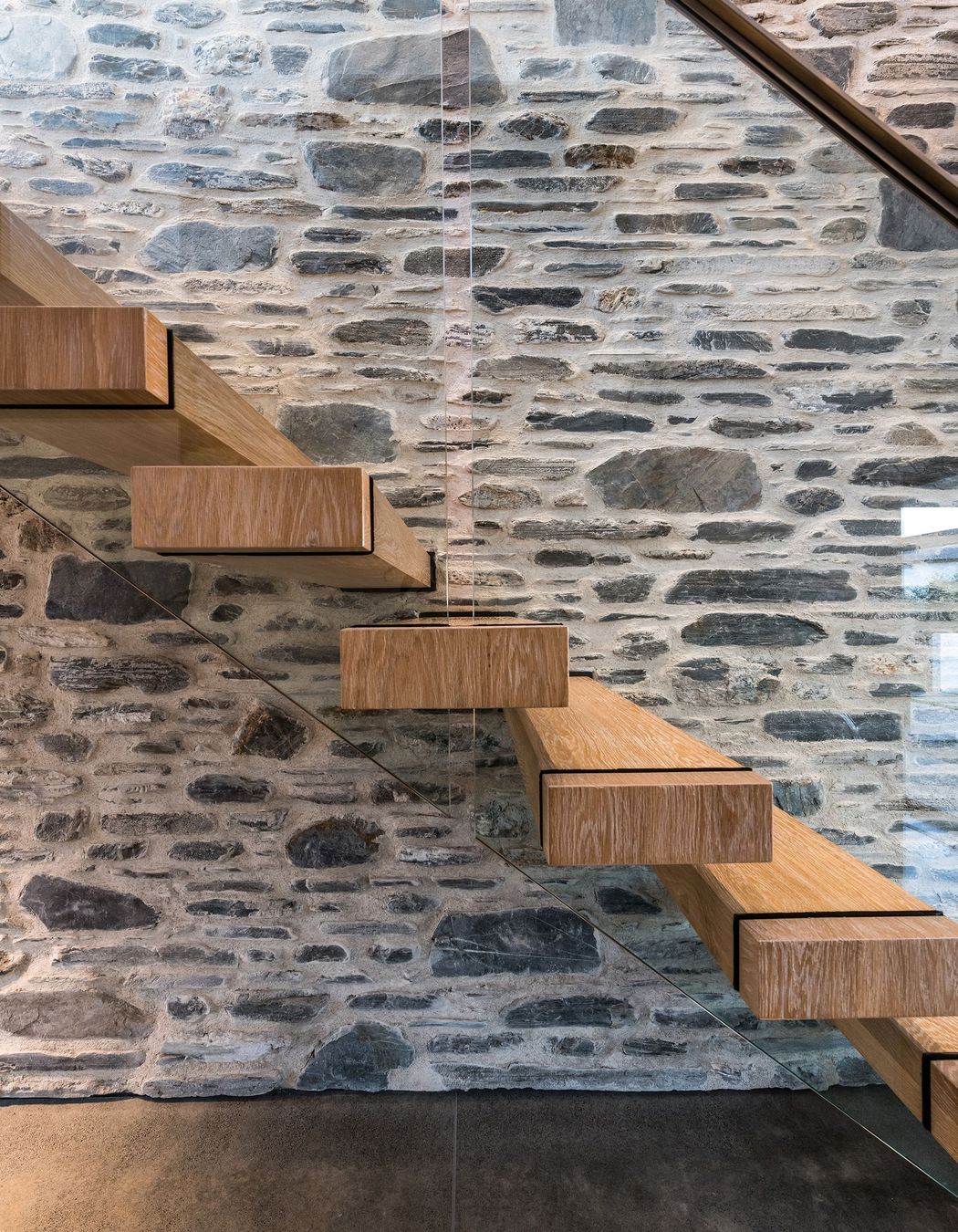 American oak stair treads add warmth against the stone and concrete.