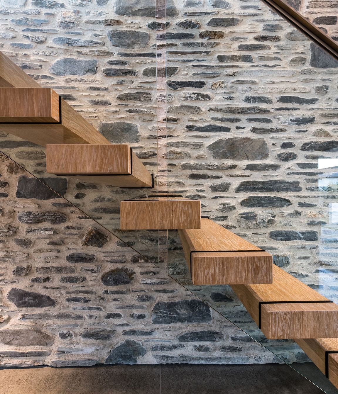 American oak stair treads add warmth against the stone and concrete.