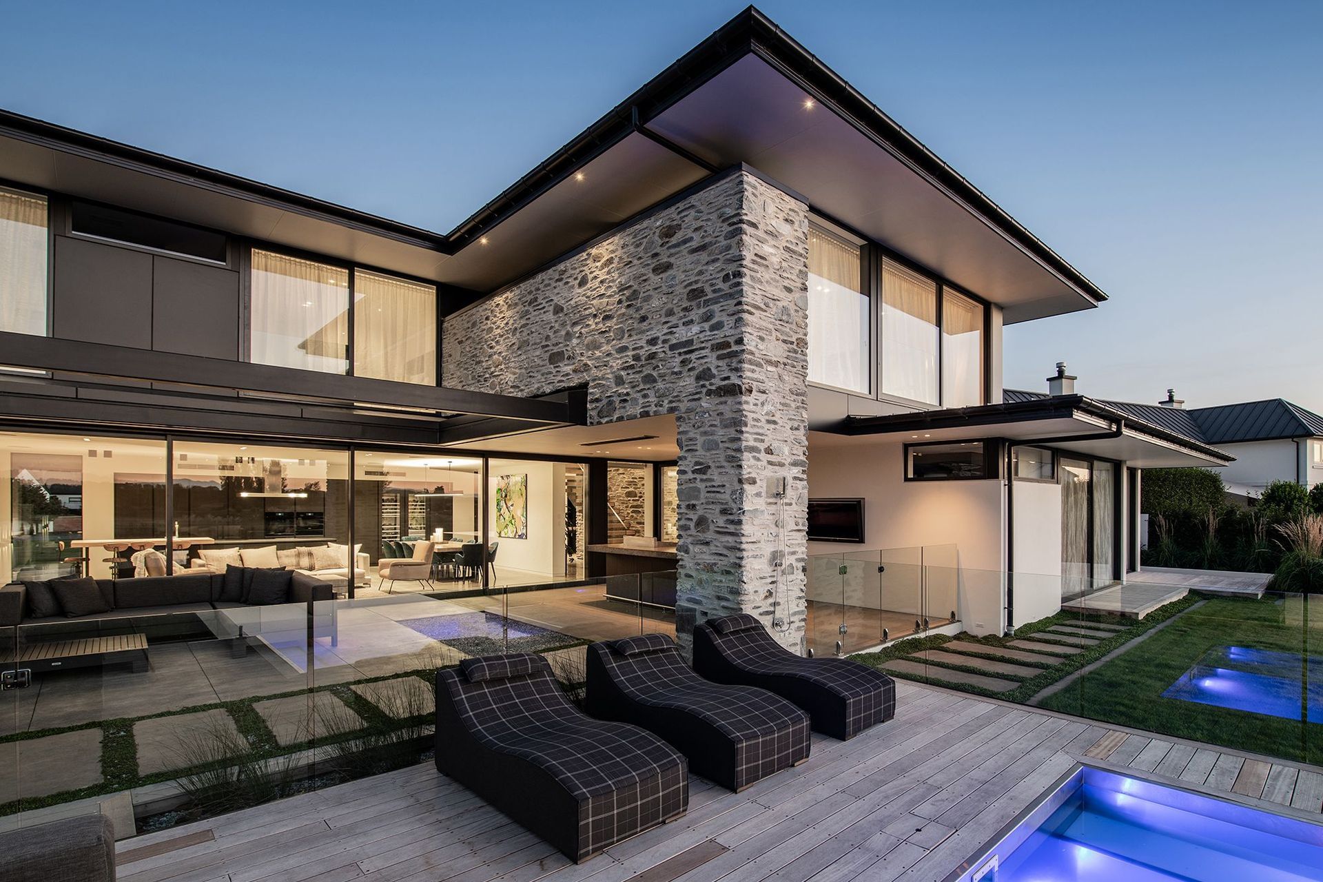 A wall of glazed sliding doors reveals the open-plan kitchen/dining/lounge area inside. A covered teppanyaki bar is nestled under the overhang.