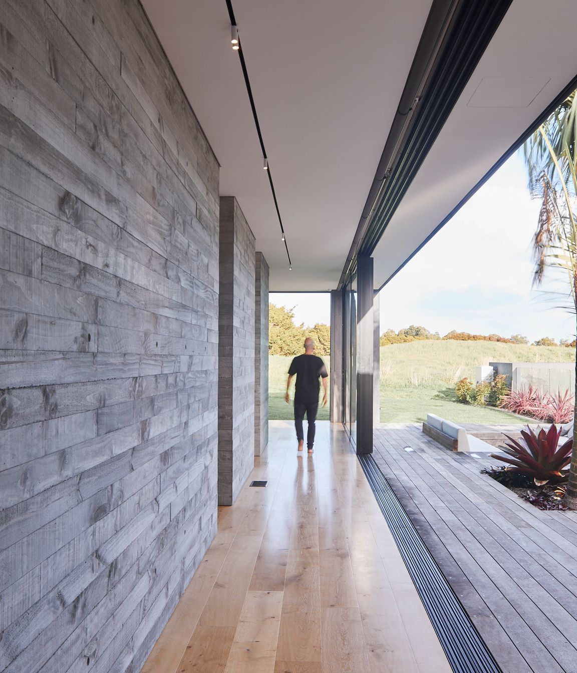 Full-width sliding doors help blur the lines between indoors and out, further enhanced by the textural nature of the chosen materials.