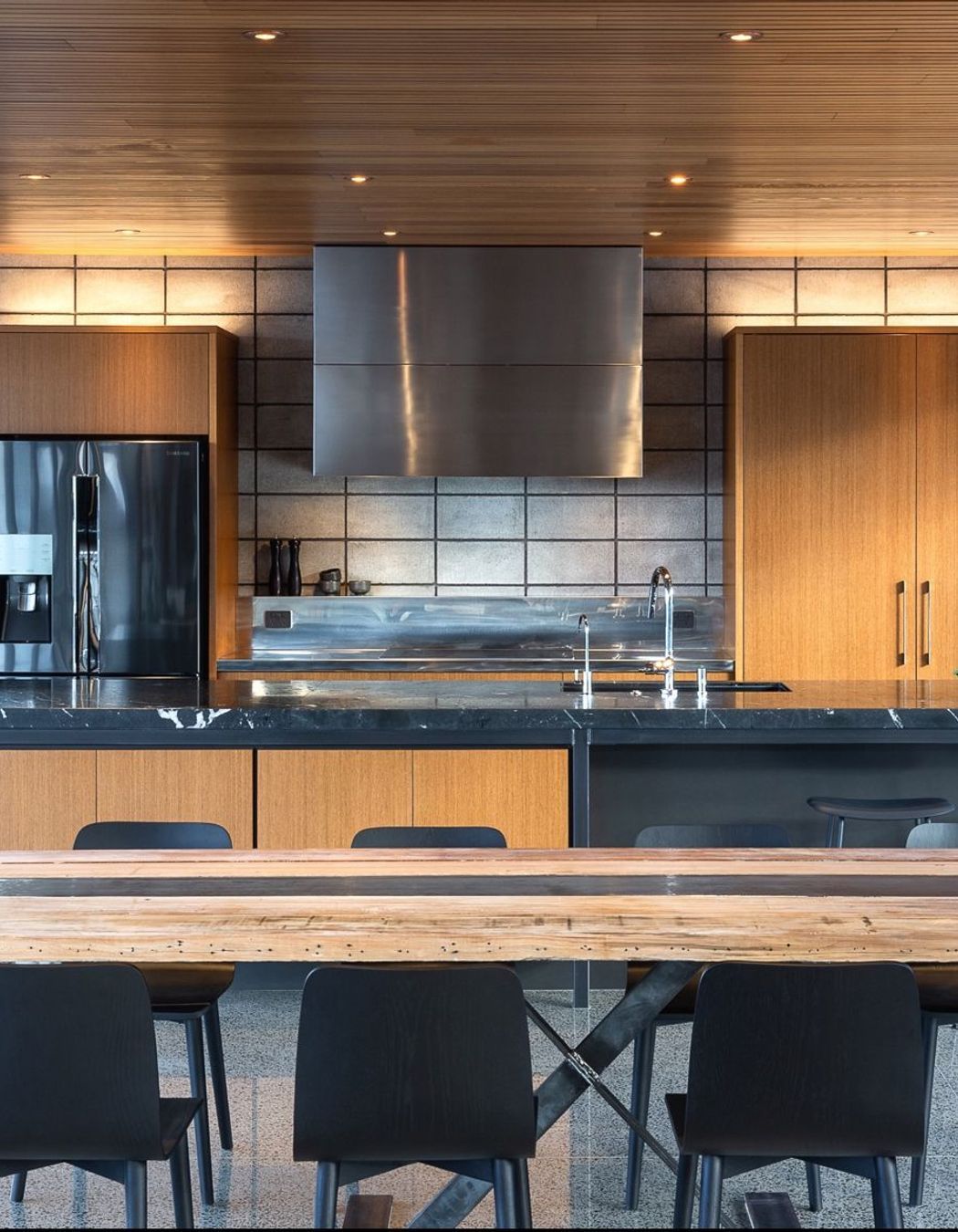 A custom stainless-steel ventilation cabinet is likewise separated from the warm teak to celebrate the block’s raw beauty. To protect the concrete surface long-term, I conceived a retractable 6mm-thin steel sheet splashback.