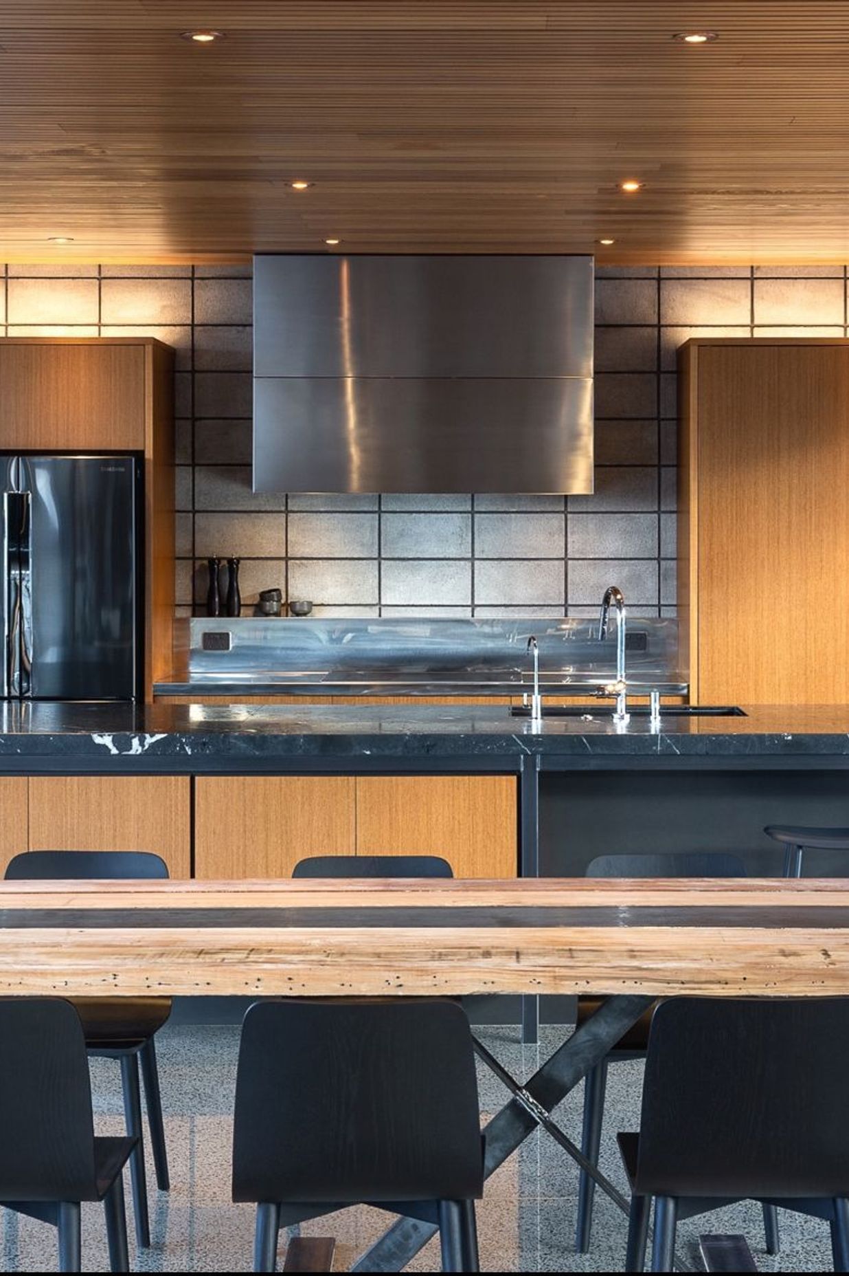 A custom stainless-steel ventilation cabinet is likewise separated from the warm teak to celebrate the block’s raw beauty. To protect the concrete surface long-term, I conceived a retractable 6mm-thin steel sheet splashback. 