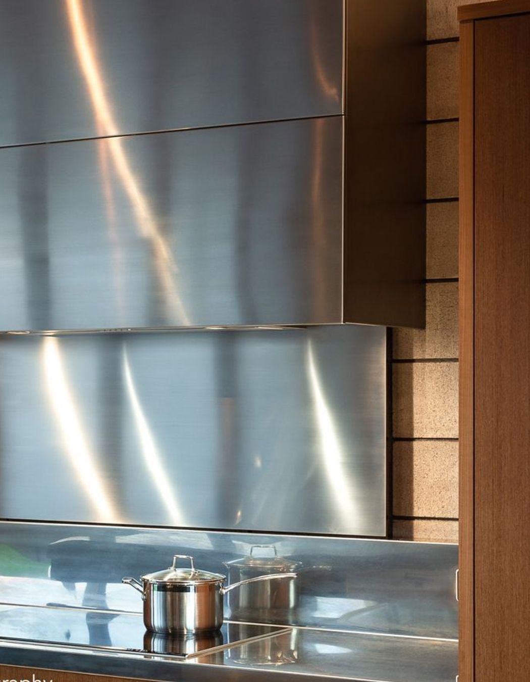 A custom stainless-steel ventilation cabinet is likewise separated from the warm teak to celebrate the block’s raw beauty. To protect the concrete surface long-term, I conceived a retractable 6mm-thin steel sheet splashback.