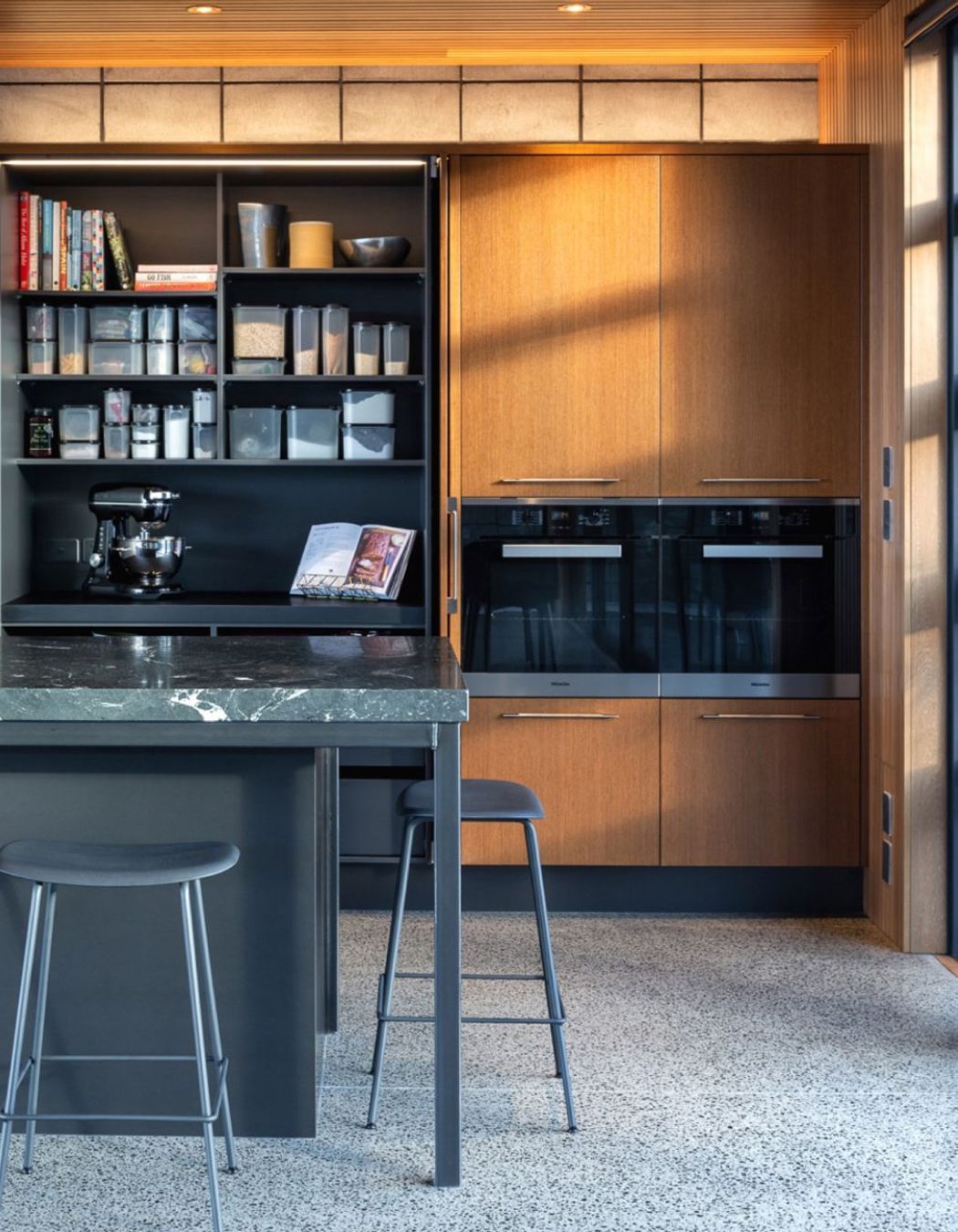 Pocket doors to the dedicated Baking Pantry keep spaces flowing and accessible. Practical storage systems with specific functionalities fill the drawers.