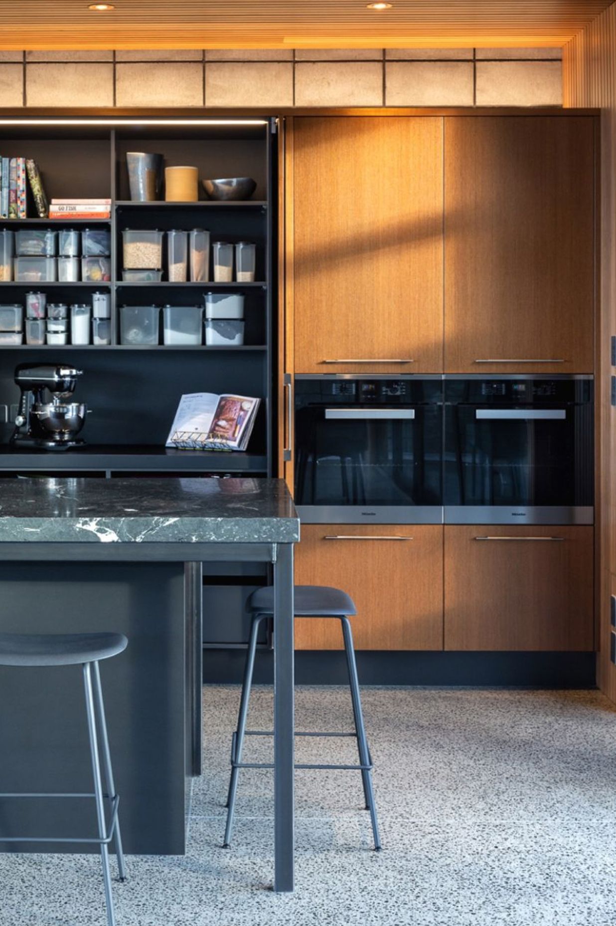 Pocket doors to the dedicated Baking Pantry keep spaces flowing and accessible. Practical storage systems with specific functionalities fill the drawers.