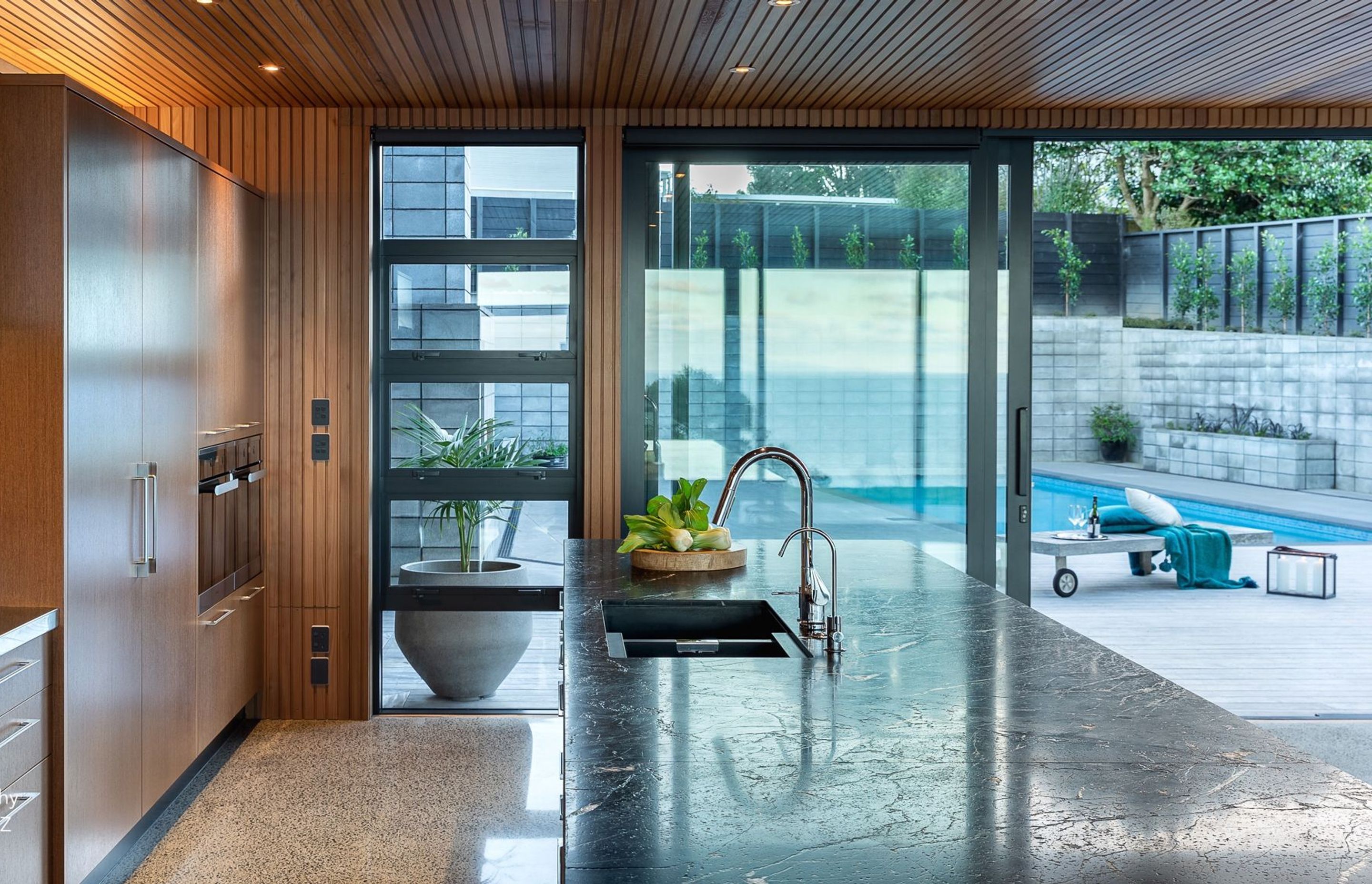 The generous island features a rugged granite bench, chosen for its tactile feel and natural character. It provides an abundance of set-down space for dishes without interrupting the workflow of the home-chef’s areas,.