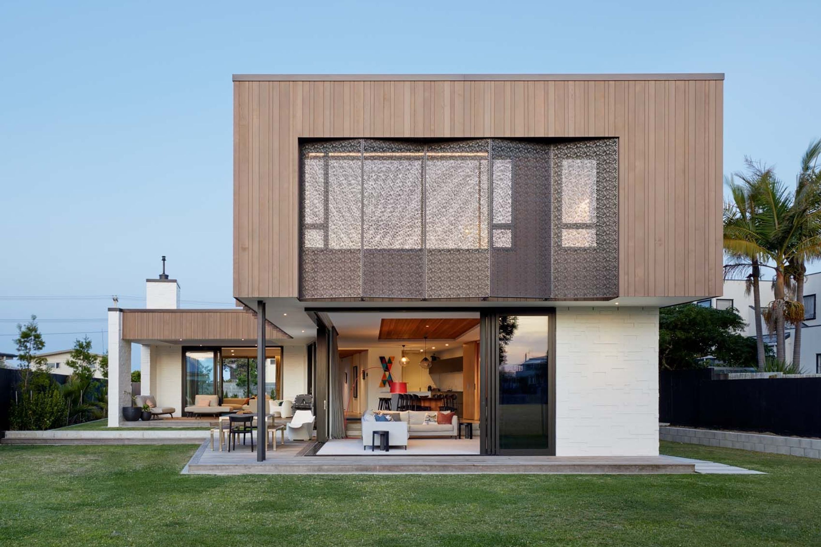 The lower floor open-plan kitchen, dining and lounge area opens out to the back lawn, while a extra lounge (left) opens up to decks on the front and back.