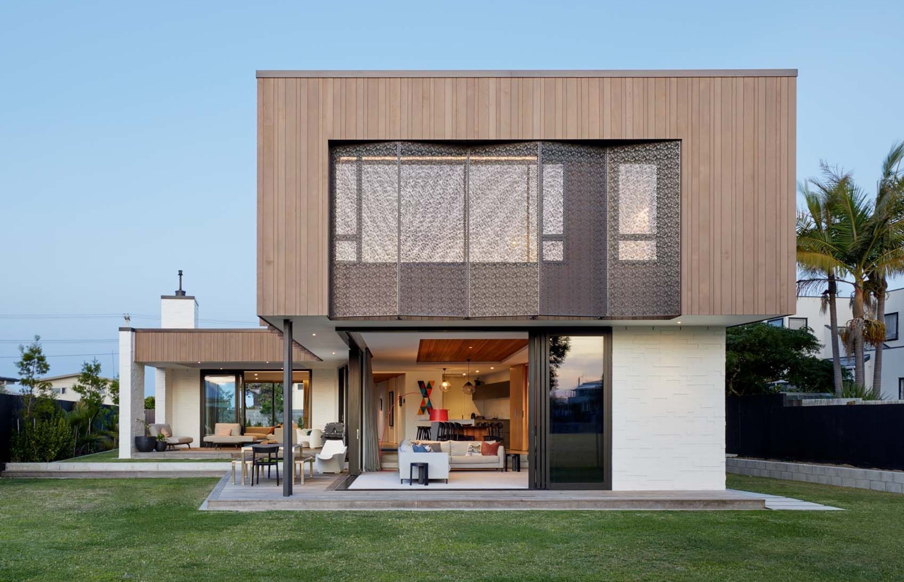 The lower floor open-plan kitchen, dining and lounge area opens out to the back lawn, while a extra lounge (left) opens up to decks on the front and back.