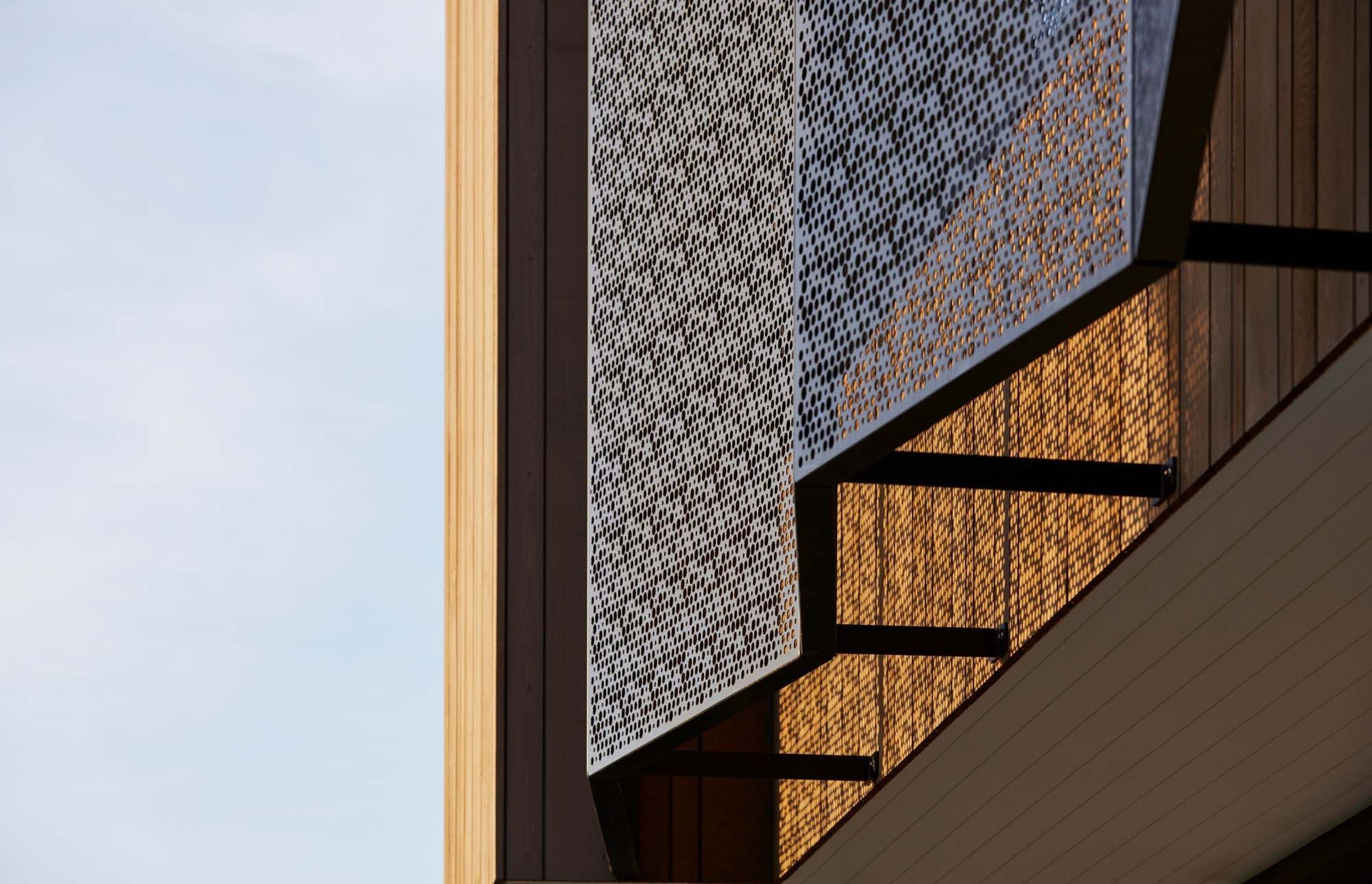 On the upper storey, fixed patterned mesh screens protect the windows at the front, facing the road, and at the rear, facing the park – offering privacy and shading.