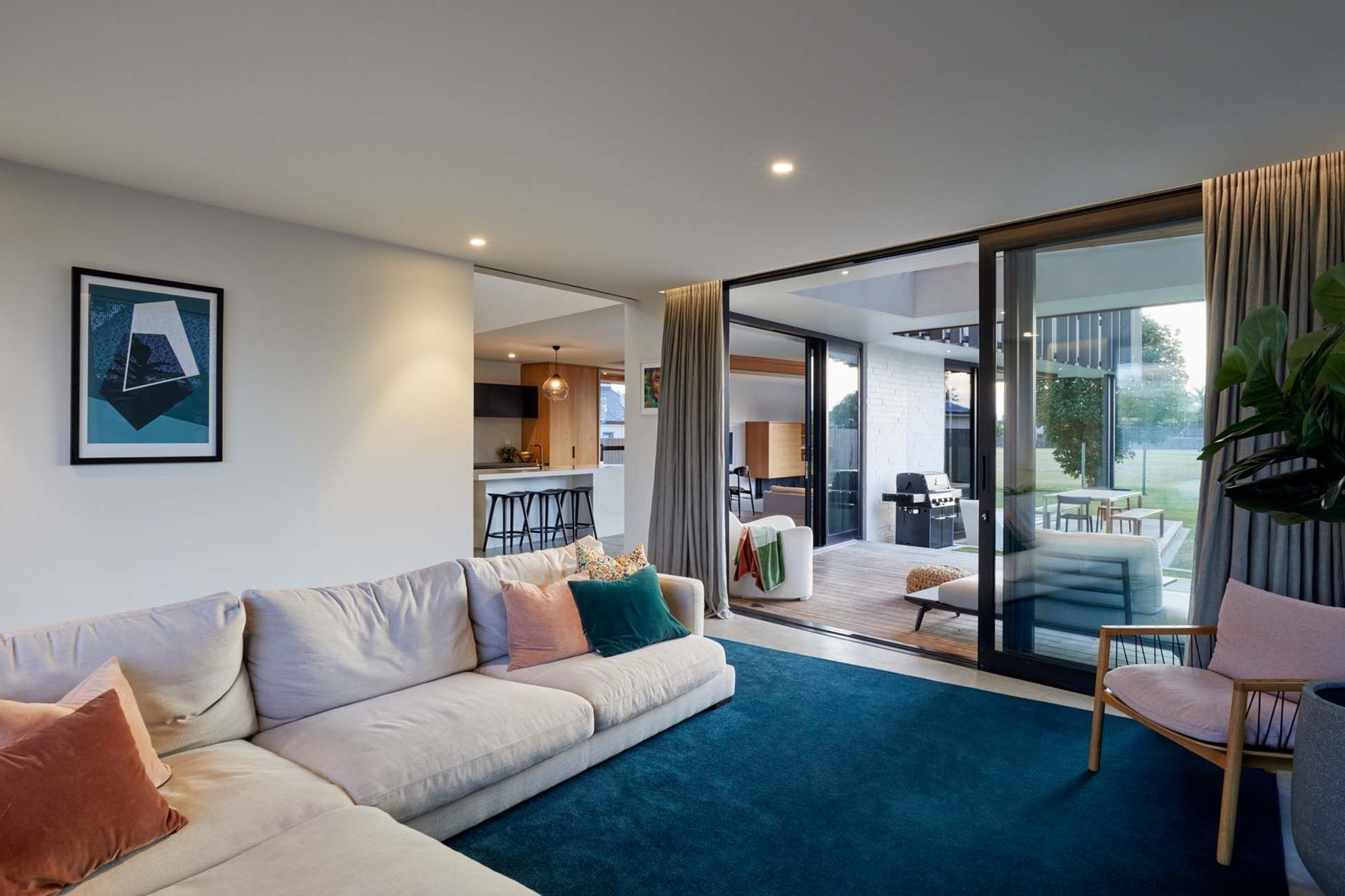 The lounge opens up to decks on either side, including a outdoor room with barbeque and dining table.