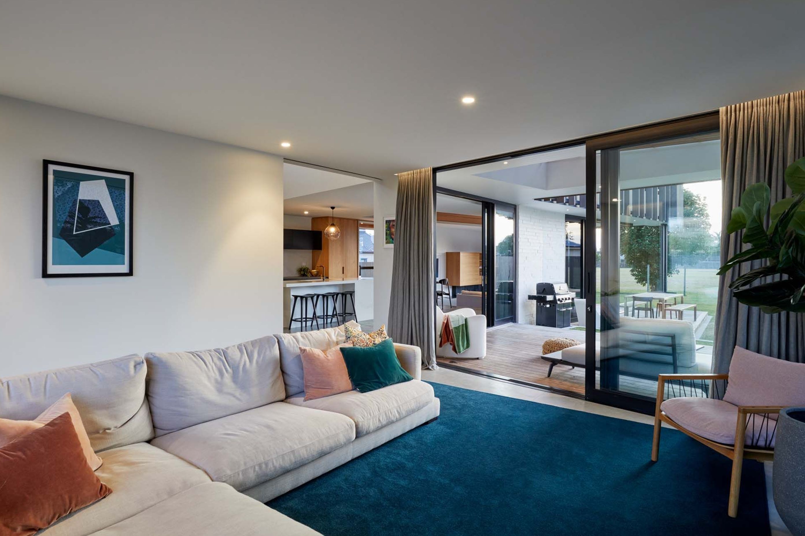 The lounge opens up to decks on either side, including a outdoor room with barbeque and dining table.